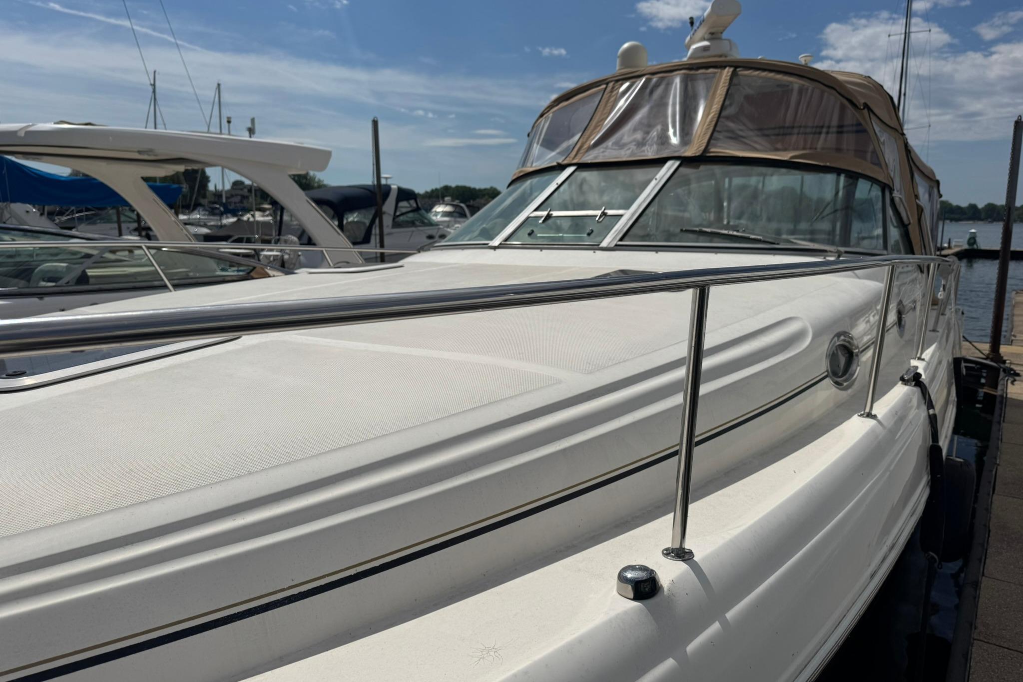 2001 Sea Ray 340 Sundancer docked at marina under clear blue sky.
