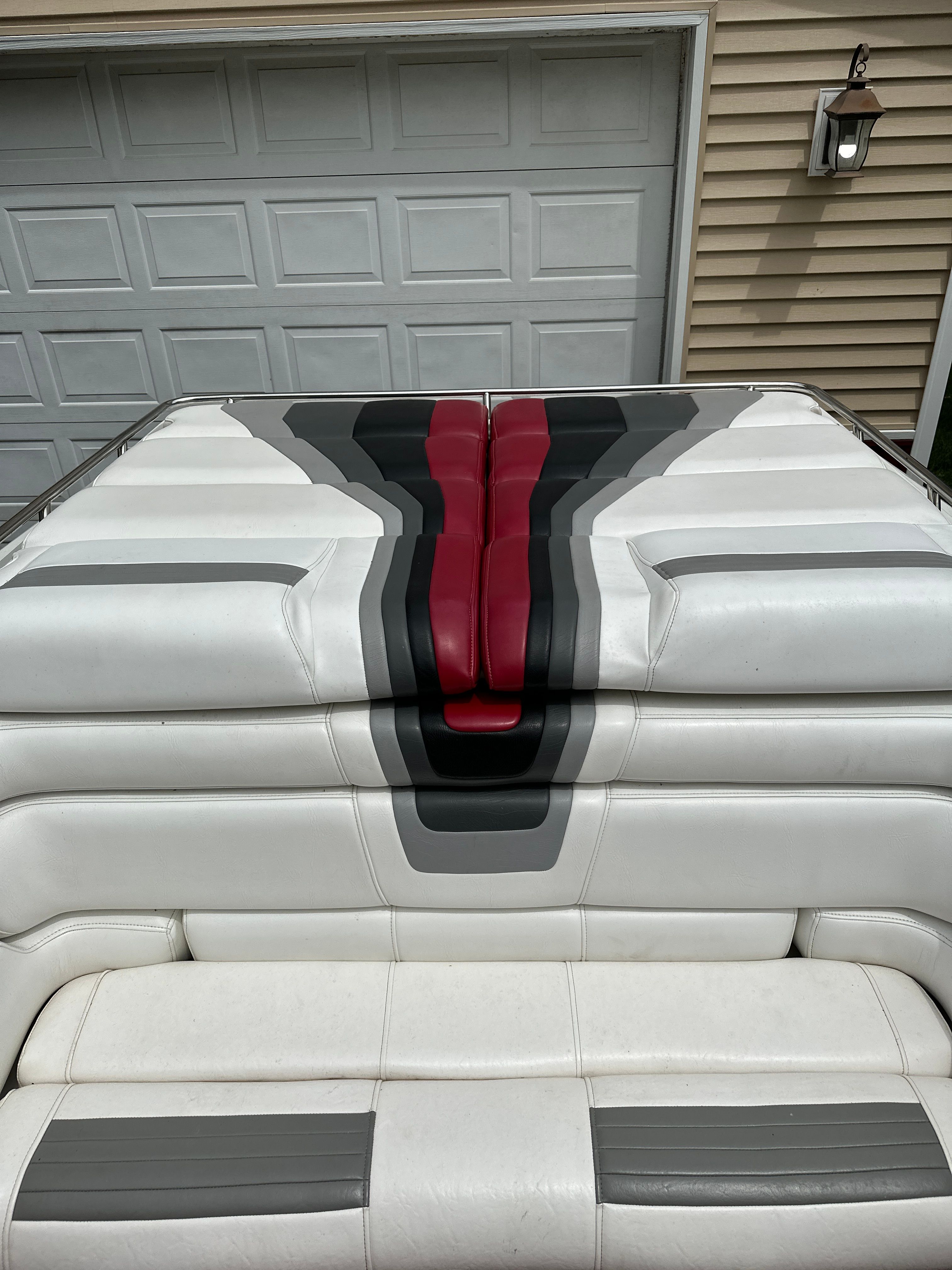 The image shows a boat's upholstery with white, gray, and red stripes.