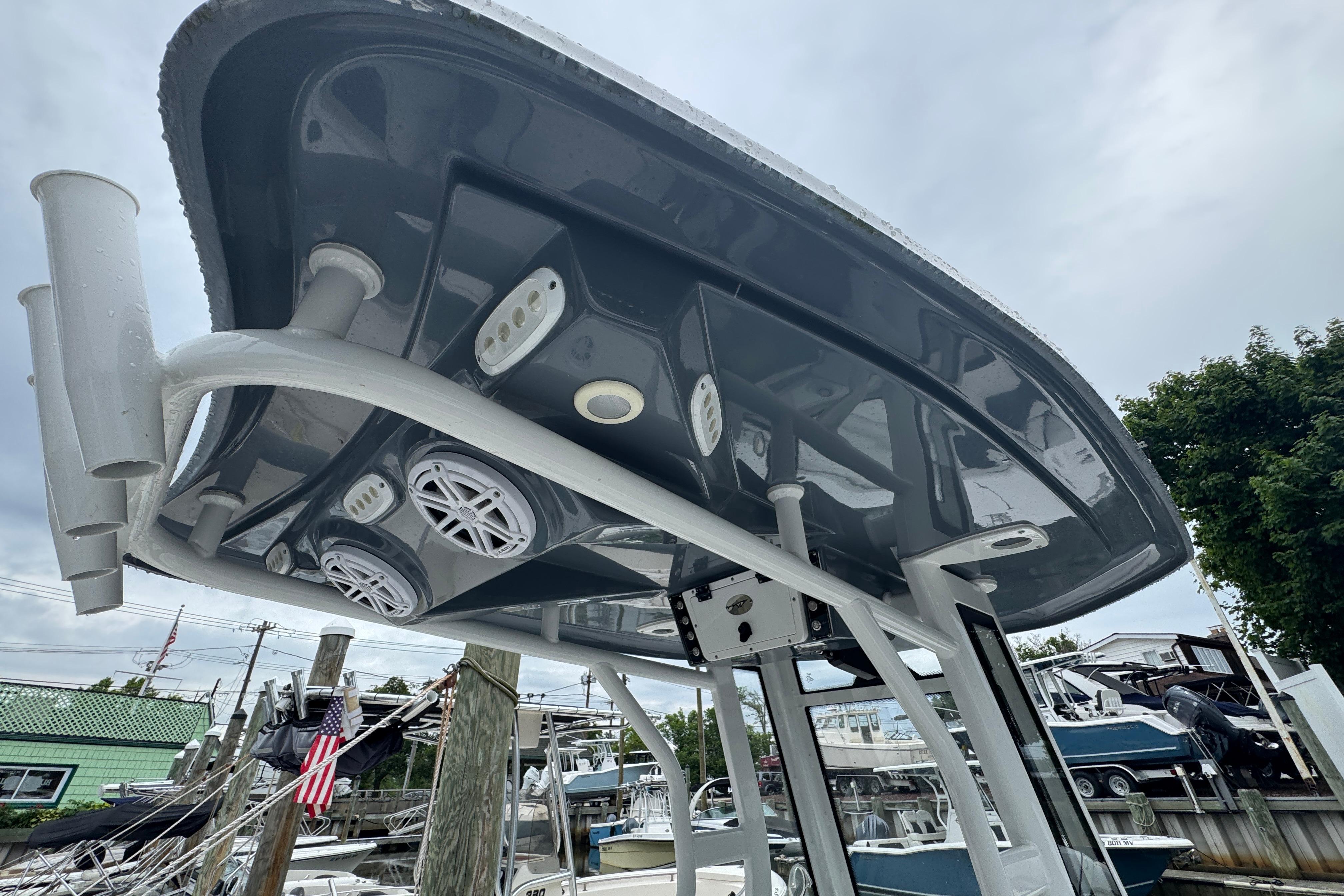 2022 Tidewater 232 SS boat with T-top, speakers, and rod holders in marina setting.