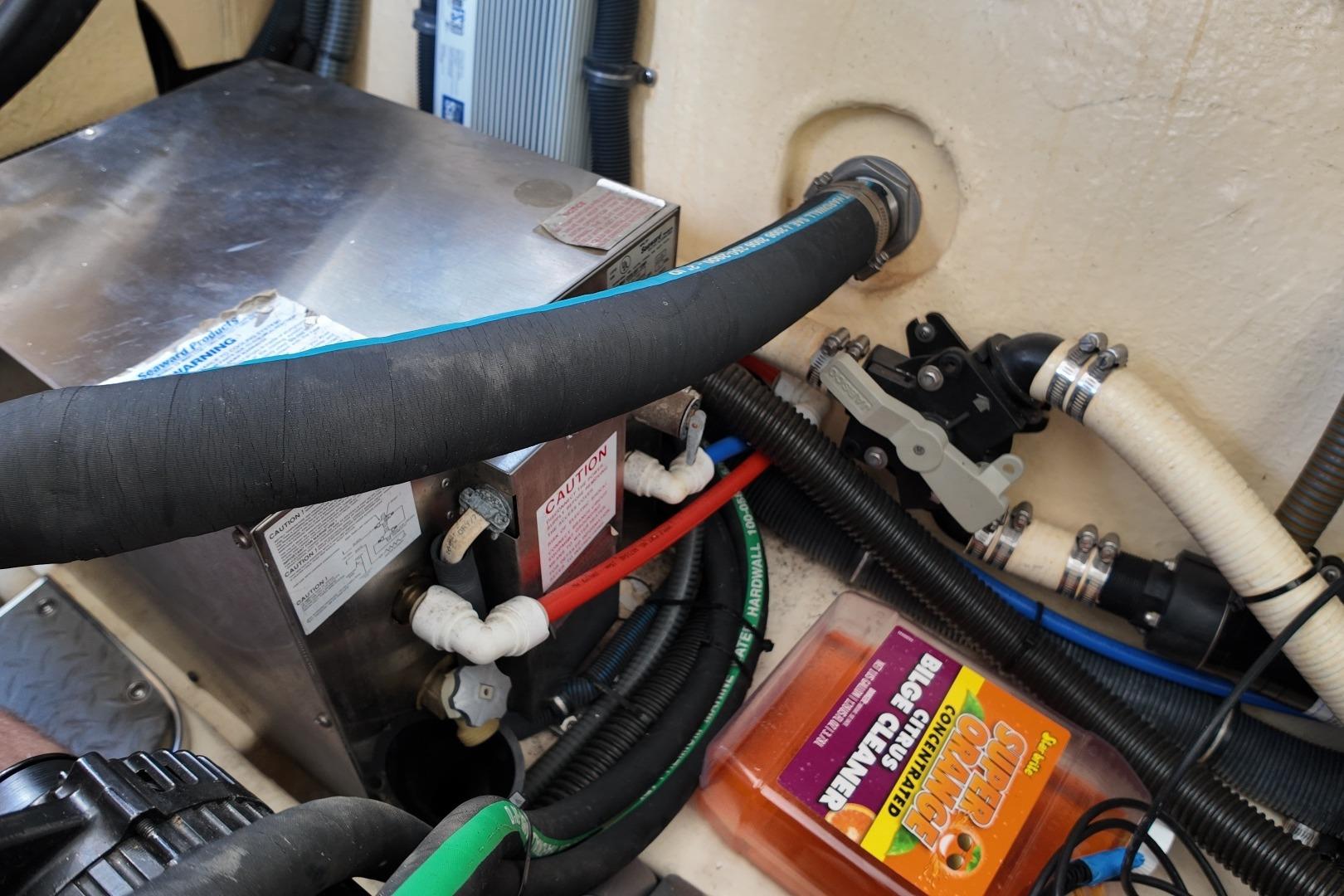 Engine compartment of a 2007 Formula 330 Sun Sport with hoses and cleaner bottle.