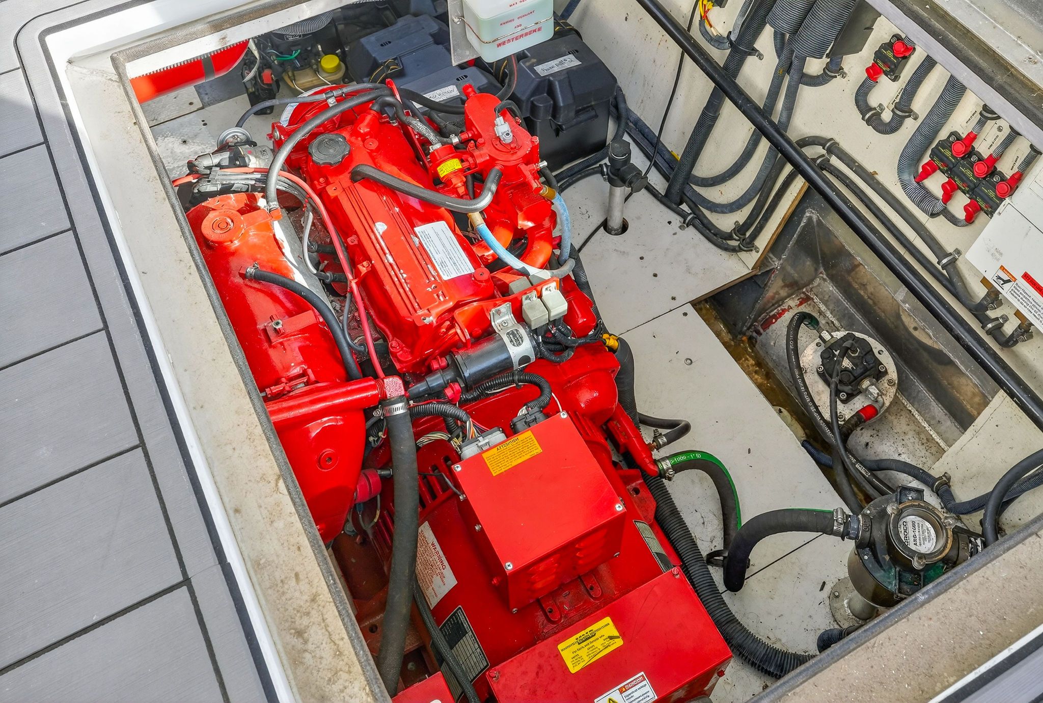 Engine compartment of a 2010 Houseboat Throughbred with red engine.