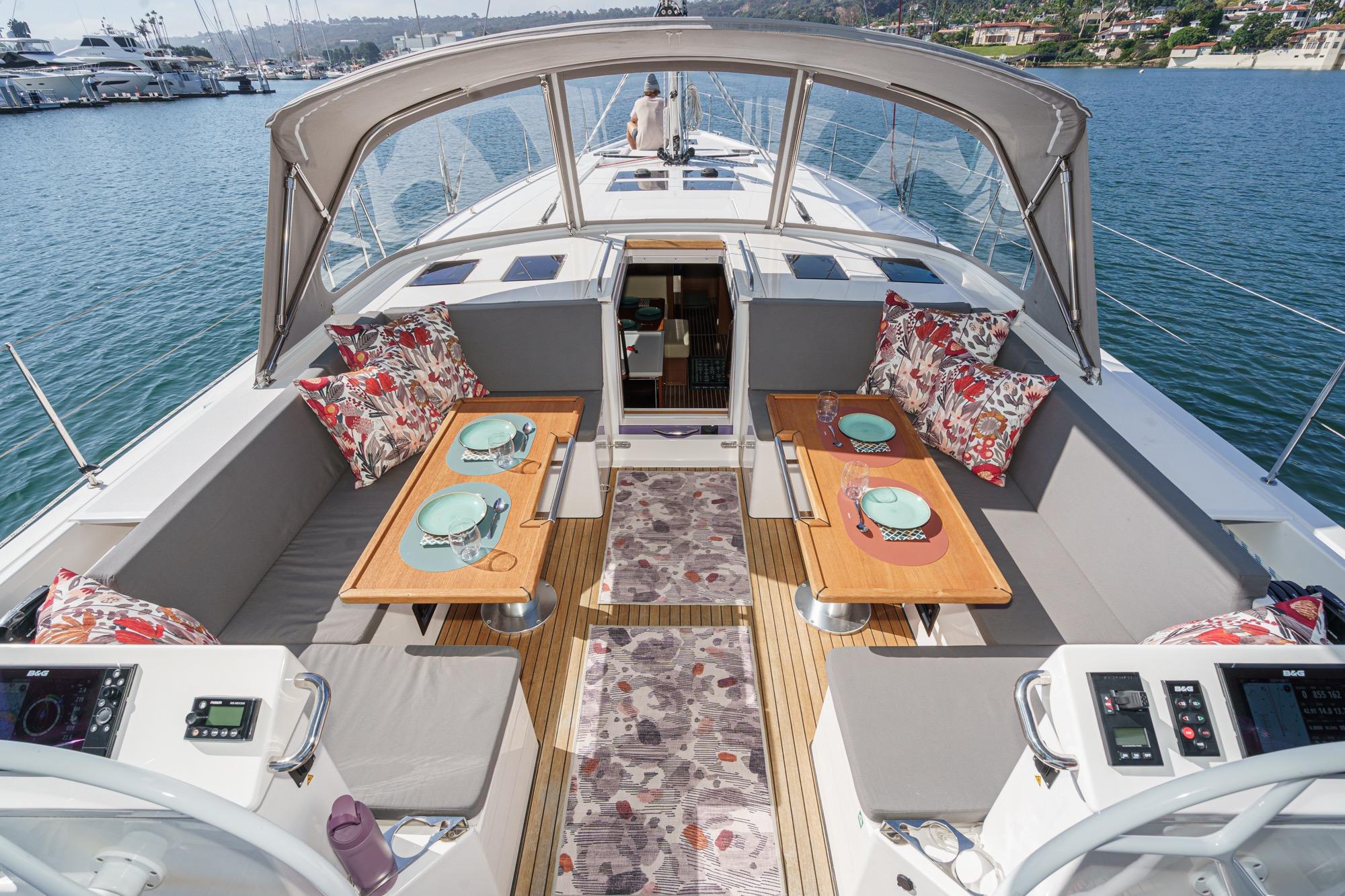 Luxurious 2023 Bavaria C50 yacht interior with elegant dining setup and scenic marina view.