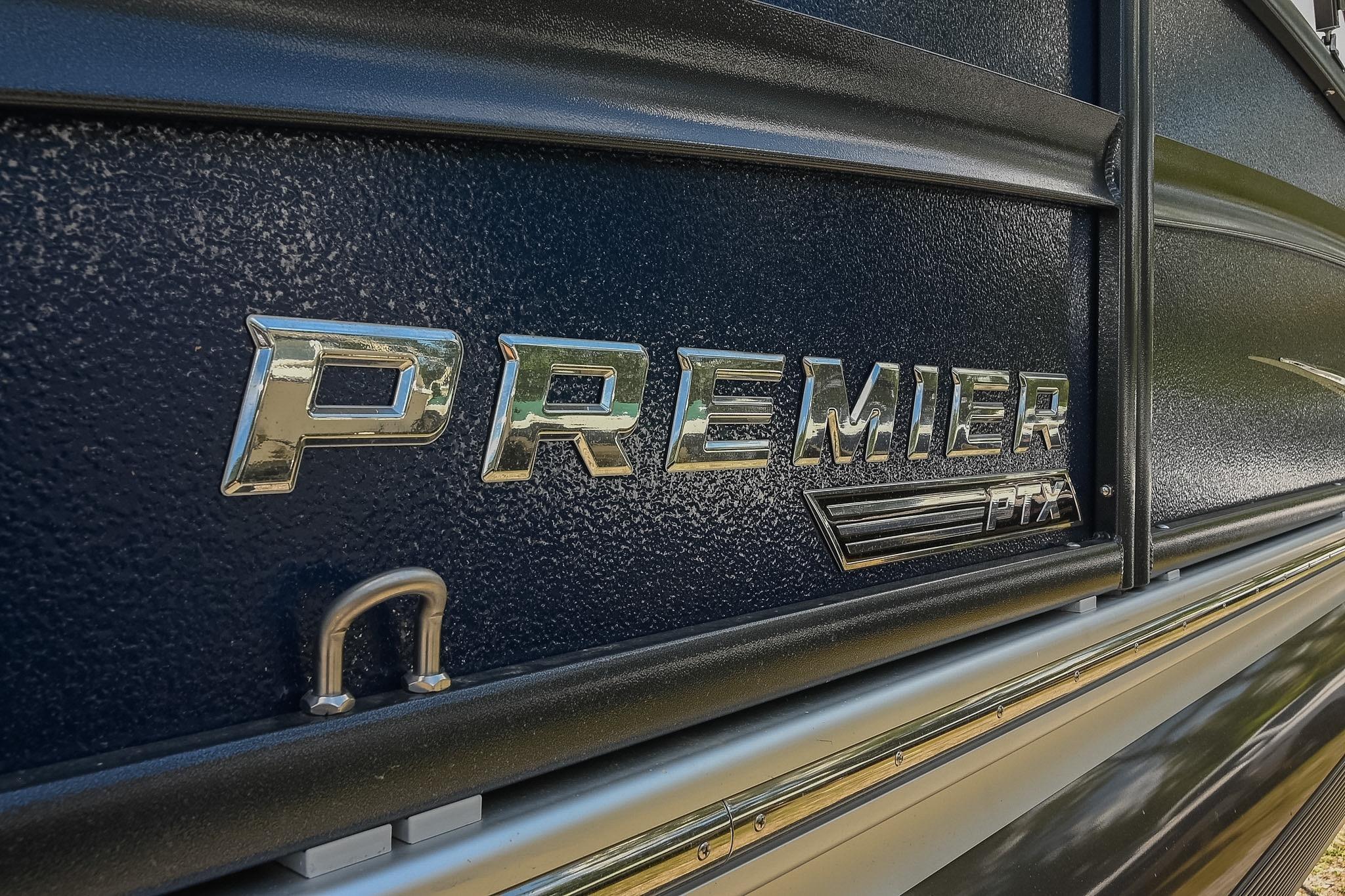 Close-up of 2023 Premier 270 Intrigue RF boat logo on textured surface.