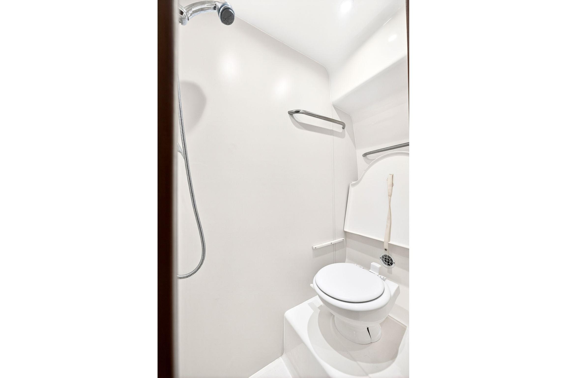Bathroom interior of 2006 Tiara Yachts 4300 Sovran, featuring a compact toilet and shower.