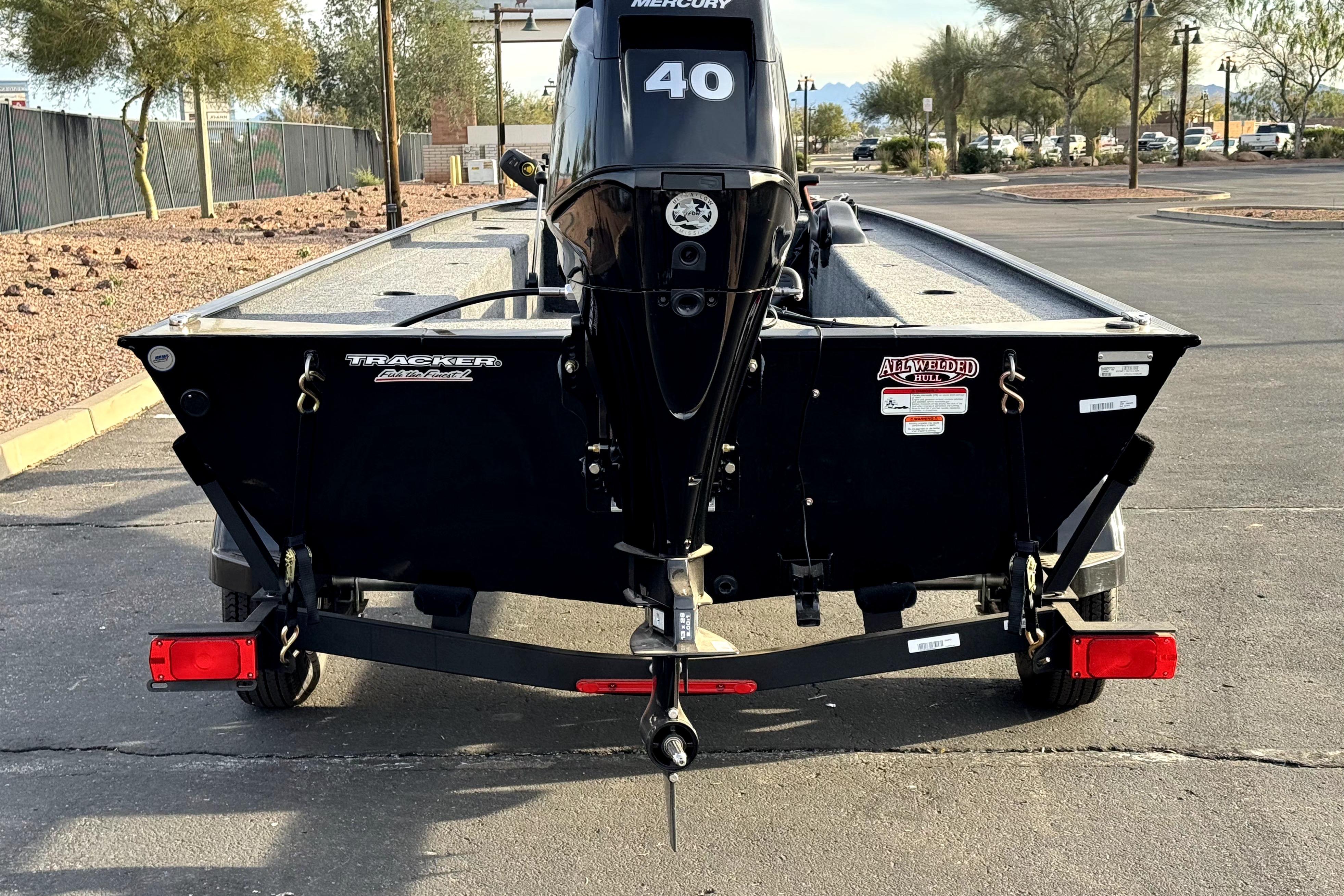 2025 Tracker Panfish 17 boat with Mercury engine, parked on a trailer in a lot.