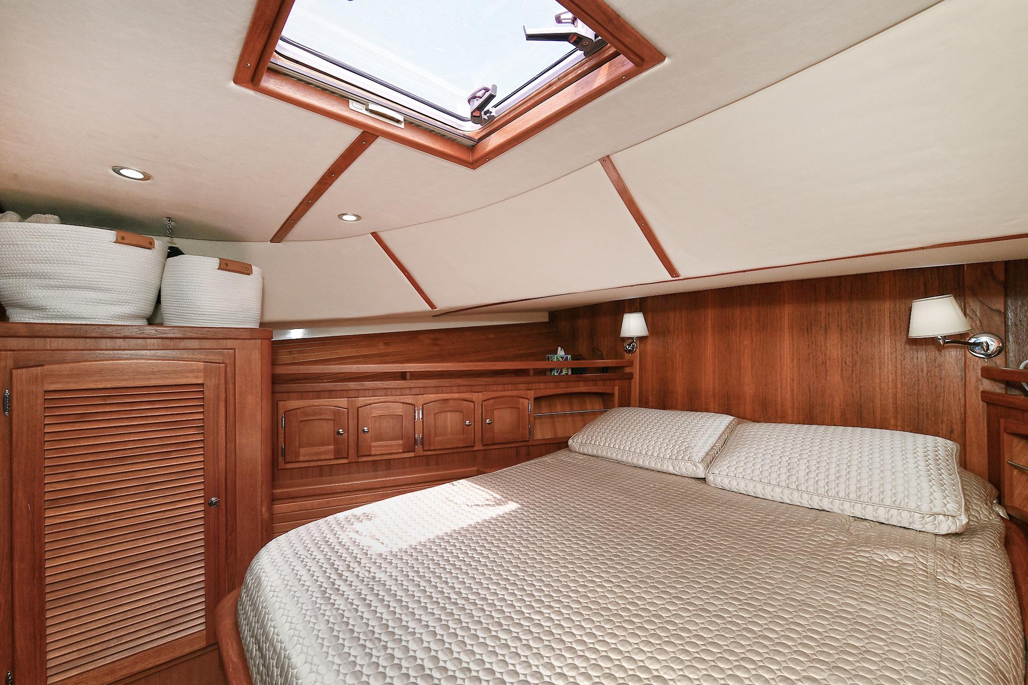 Luxurious 2005 San Juan Downeast Express cabin with wood paneling and skylight.