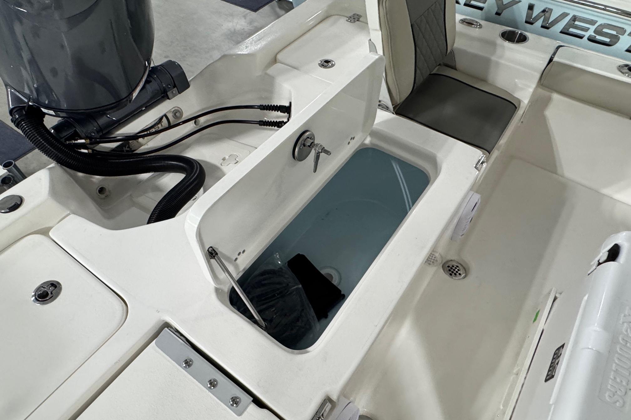 2026 Key West 210 Bay Reef boat interior with open storage compartment and seating.