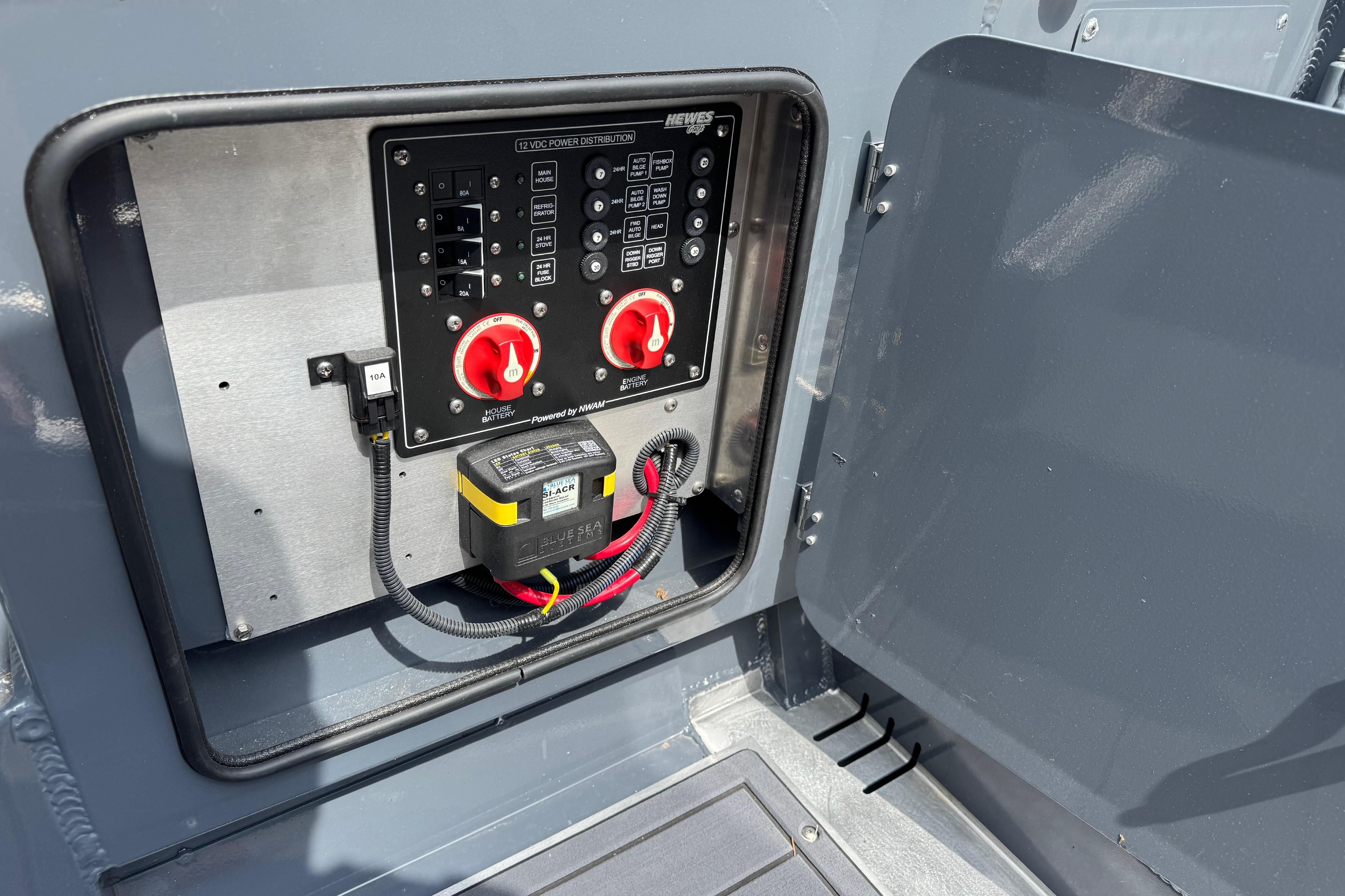 Electrical panel of 2025 Hewescraft 240 Pacific Cruiser with battery switches and wiring.