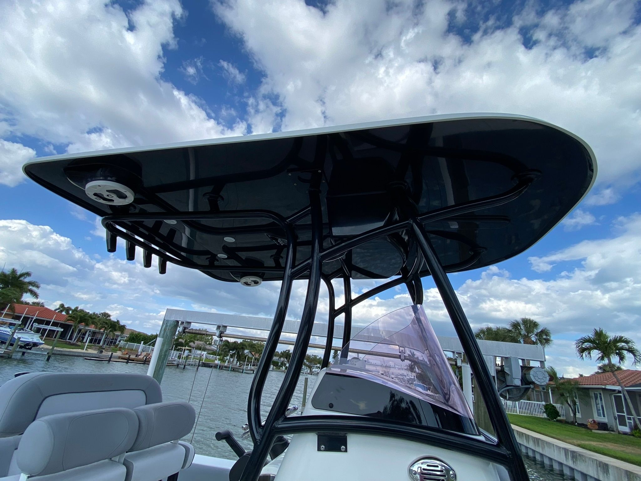 NauticStar Legacy 2021 boat with T-top and seating area by the water.