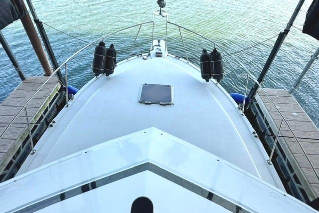 1989 Carver 32 Aft Cabin Motor Yacht docked, view from bow, calm water.
