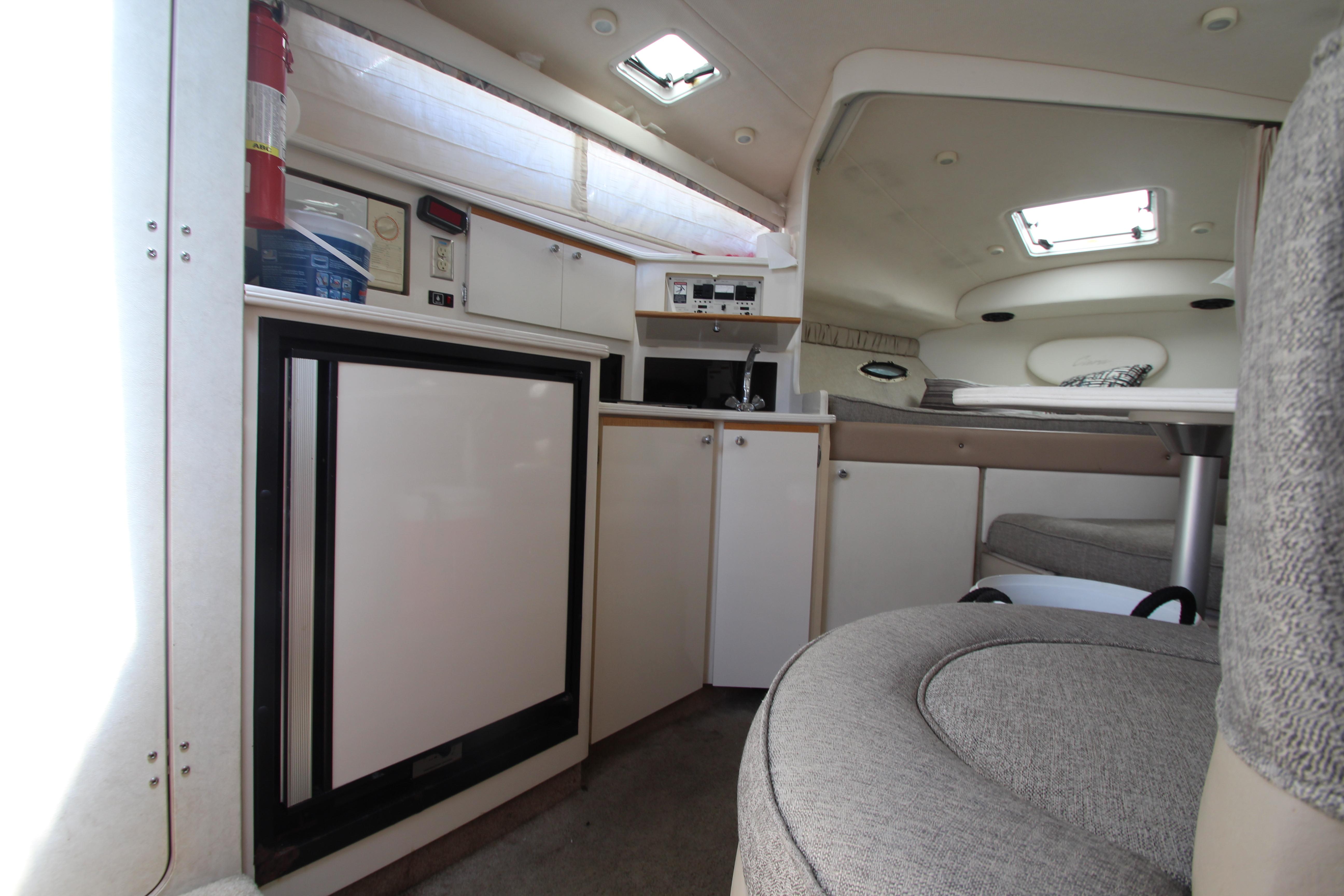 Interior of 1999 Bayliner 3055 Ciera boat, featuring kitchenette and seating area.