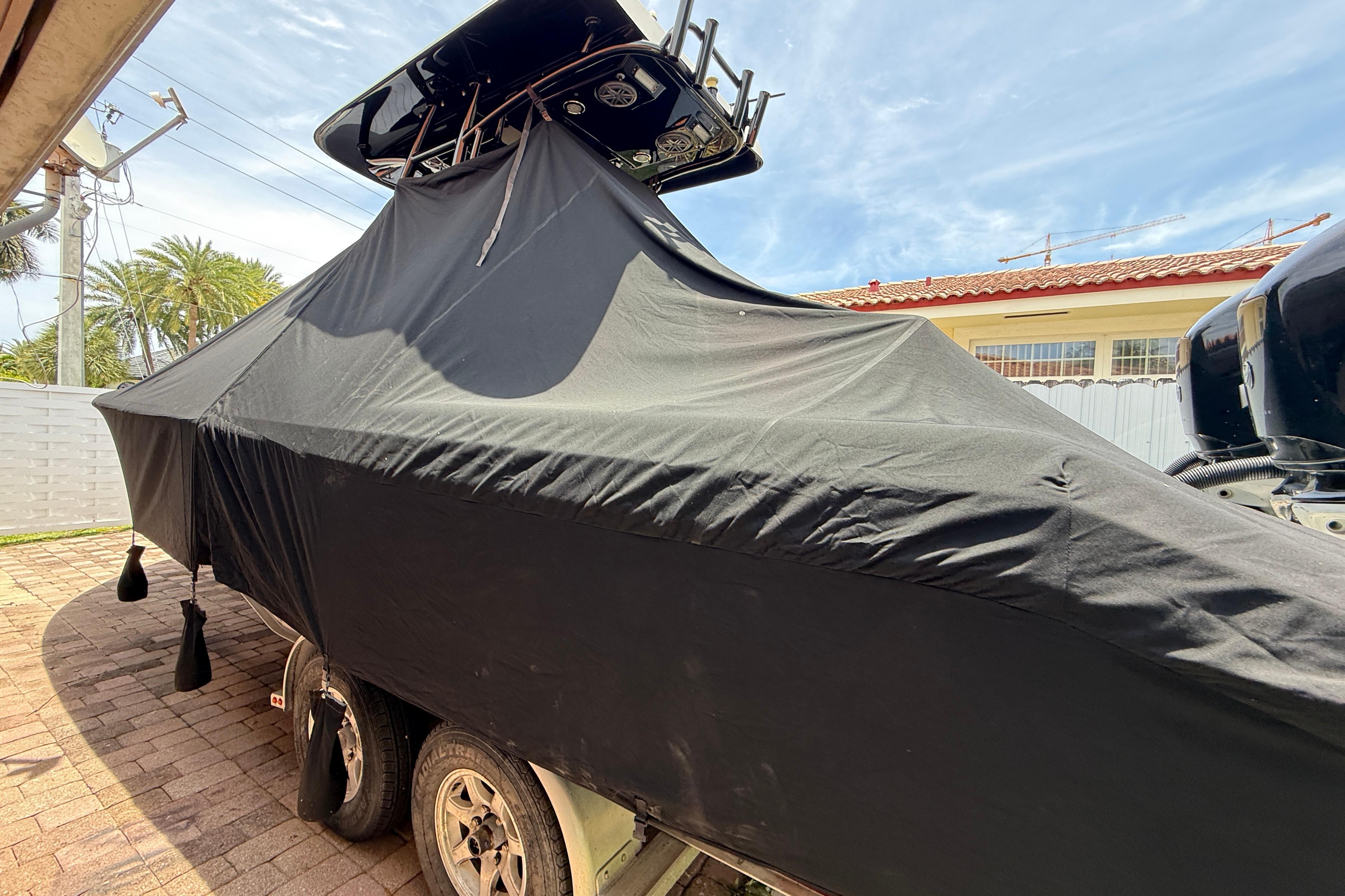 Covered 2015 Blackwood 27 boat on trailer, parked outdoors under clear sky.
