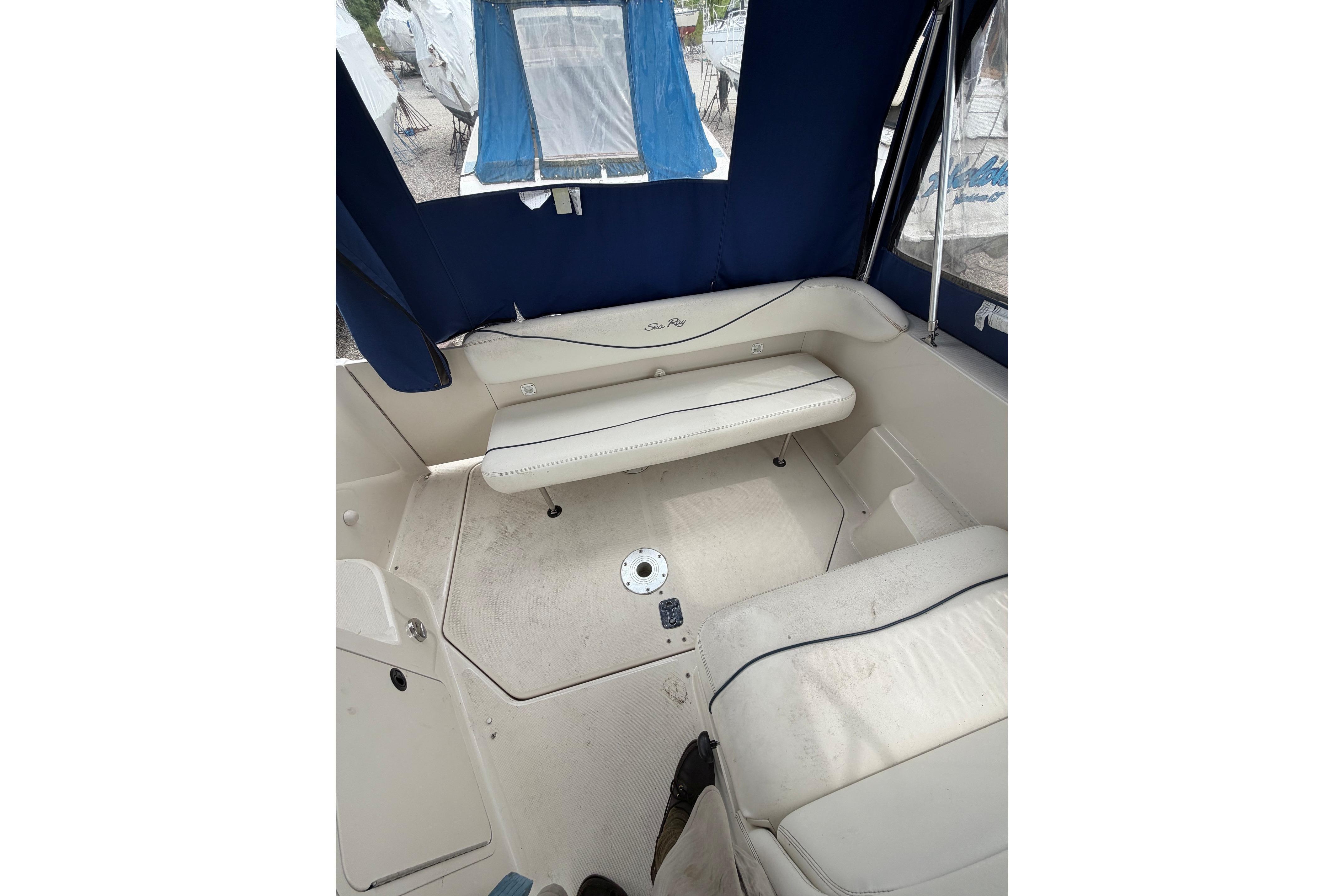 Interior view of a 2000 Sea Ray 240 Sundancer boat with blue canopy and seating.