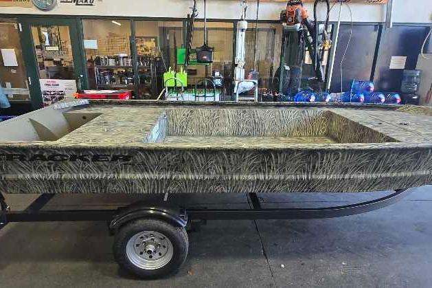 2026 Tracker Grizzly 1648 Utility boat on trailer in a workshop setting.