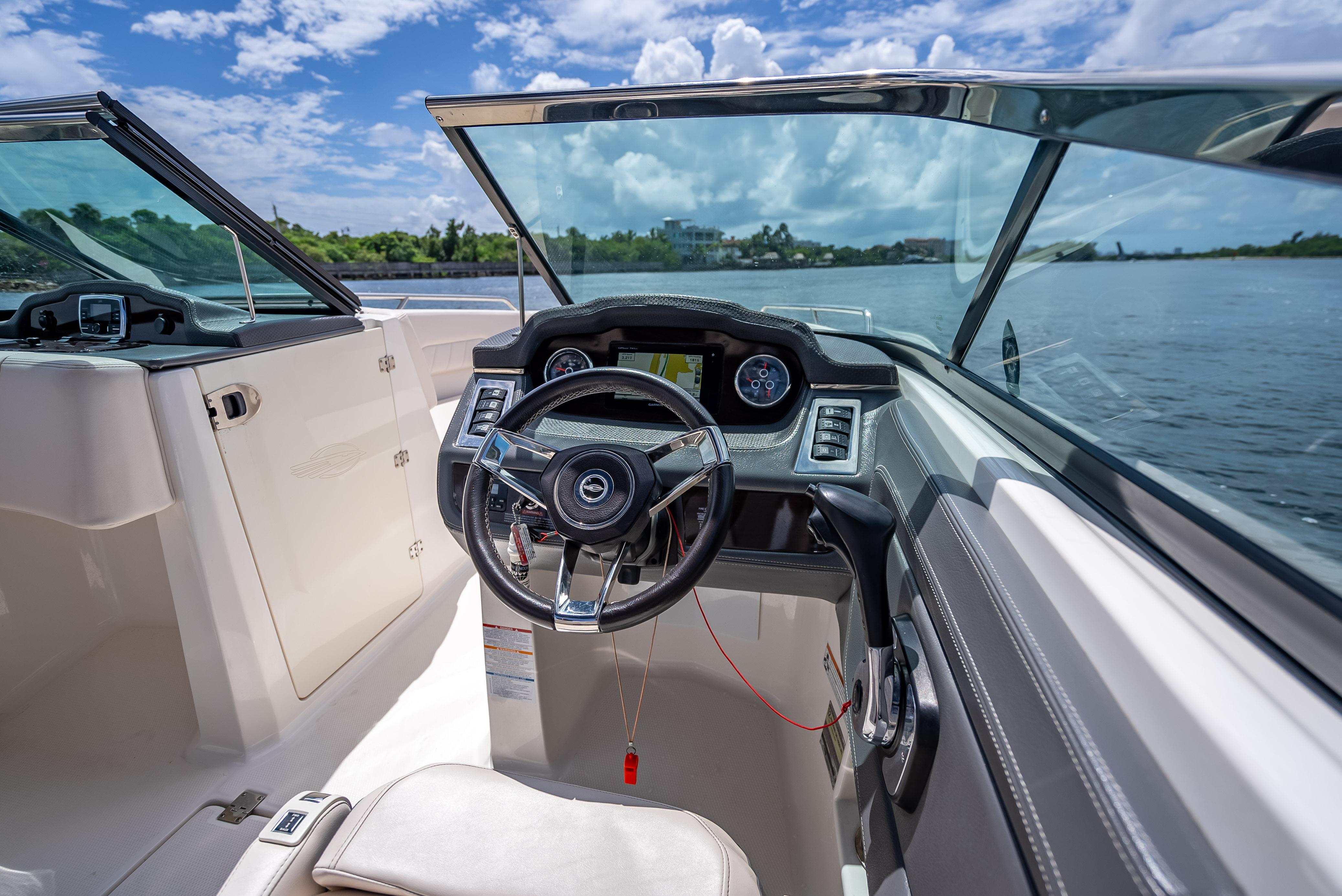 2017 Chaparral 227 SSX boat interior with steering wheel, dashboard, and water view.