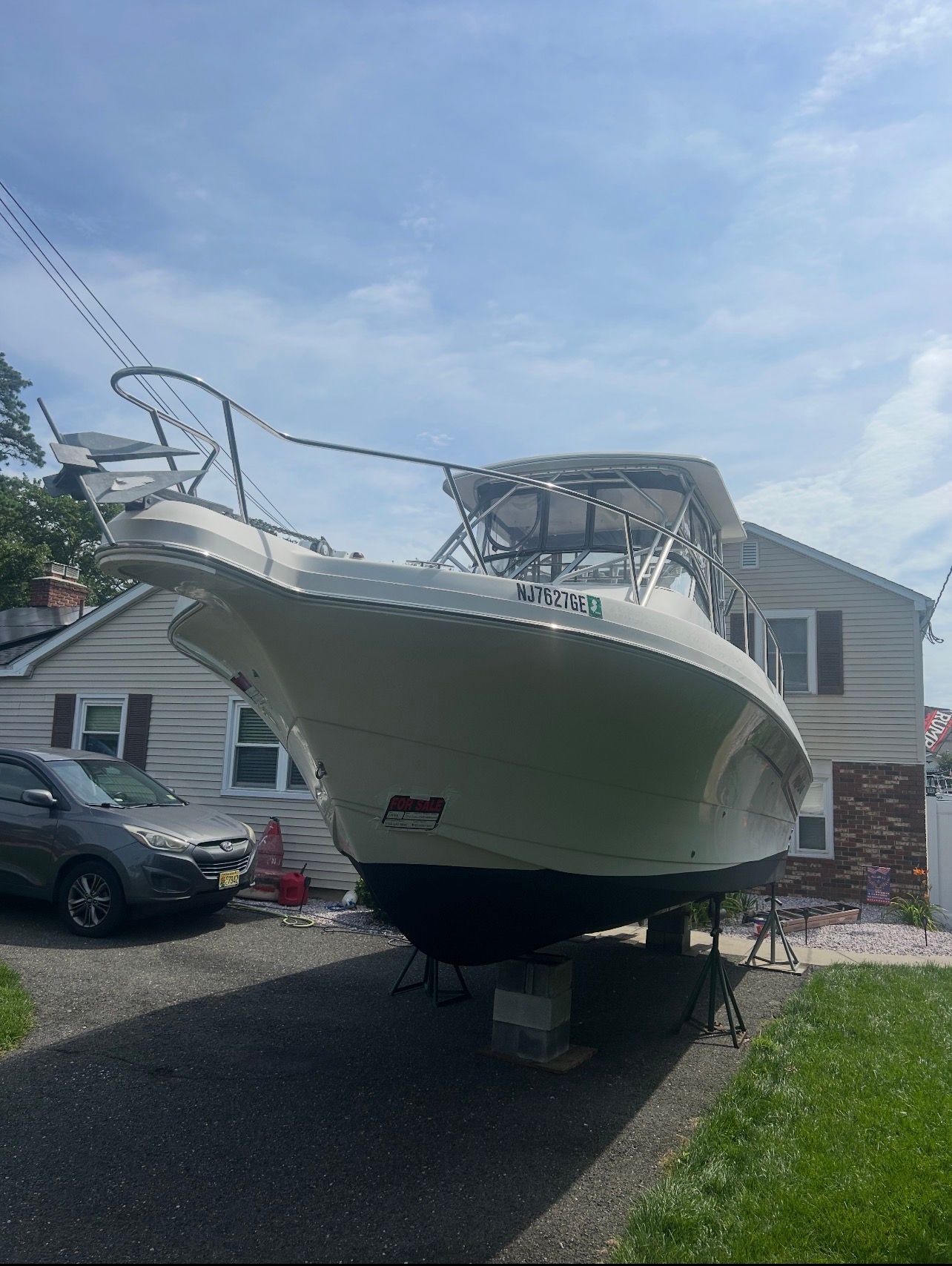 A Pro-Line 2950 Walkaround boat is on a trailer in a driveway.