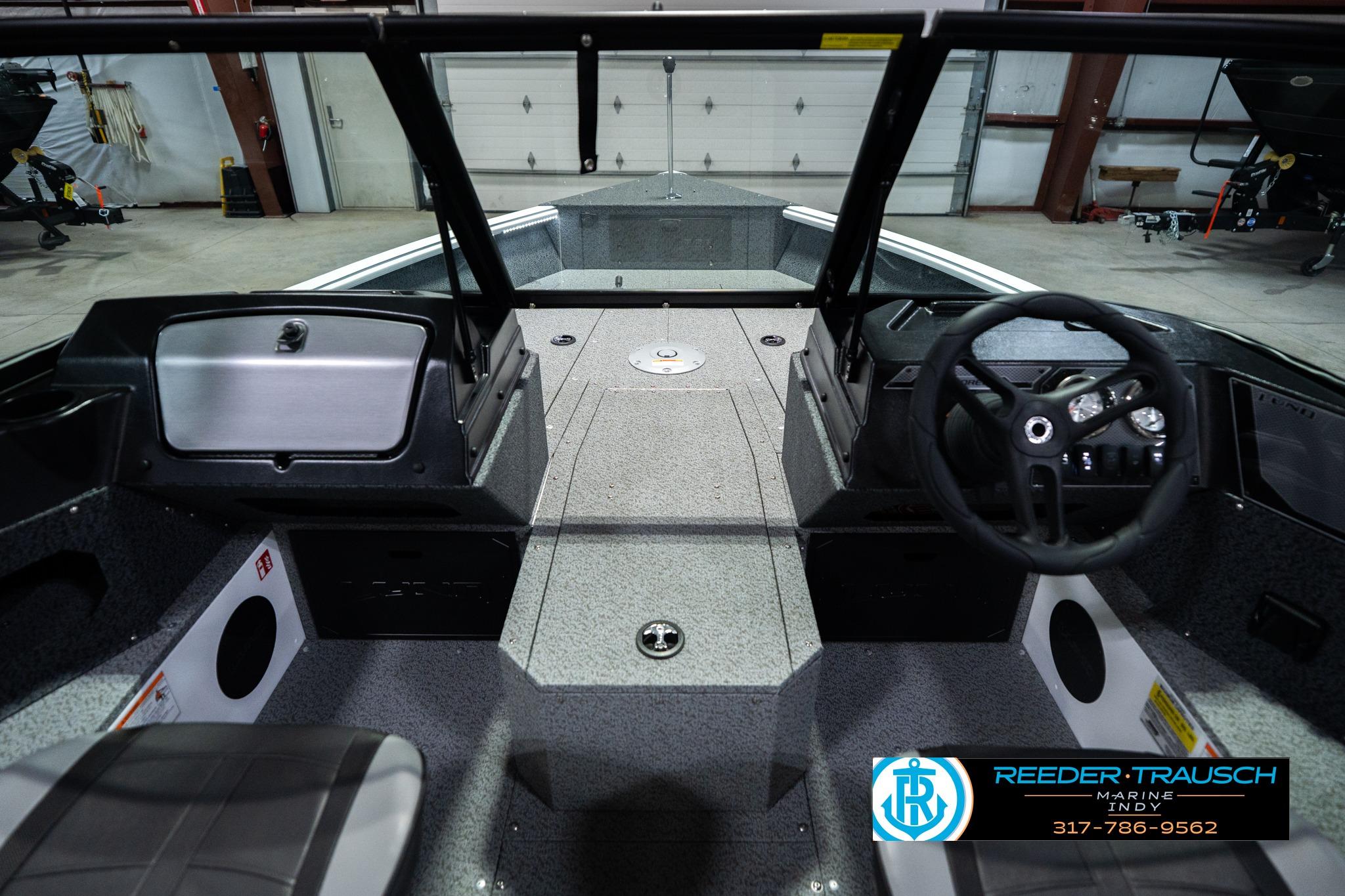 2026 Lund 1700 Explorer Sport boat interior with steering wheel and dashboard in showroom.