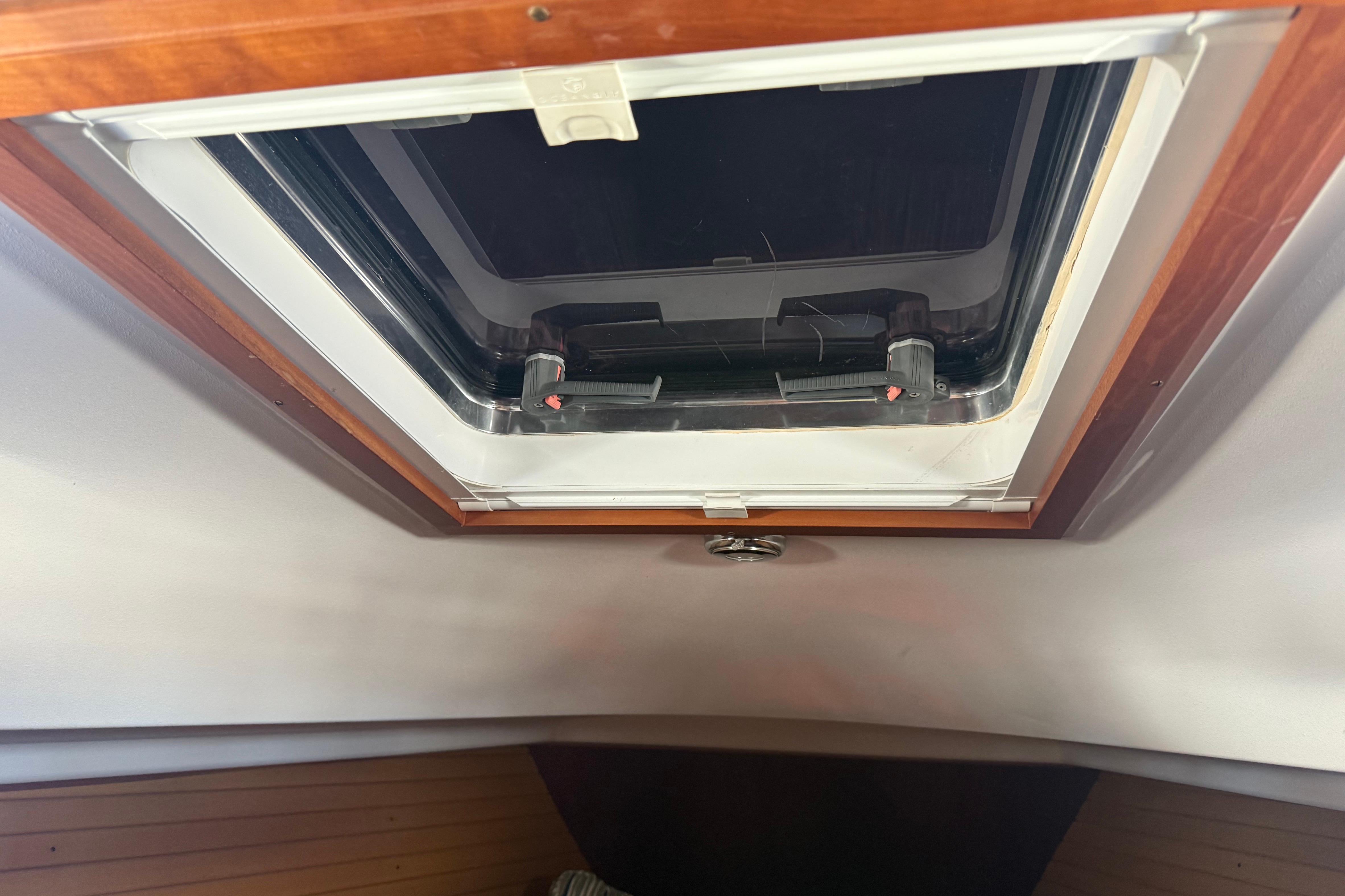 Hatch interior of 2004 Sabre 386 sailboat, featuring wooden trim and open skylight.