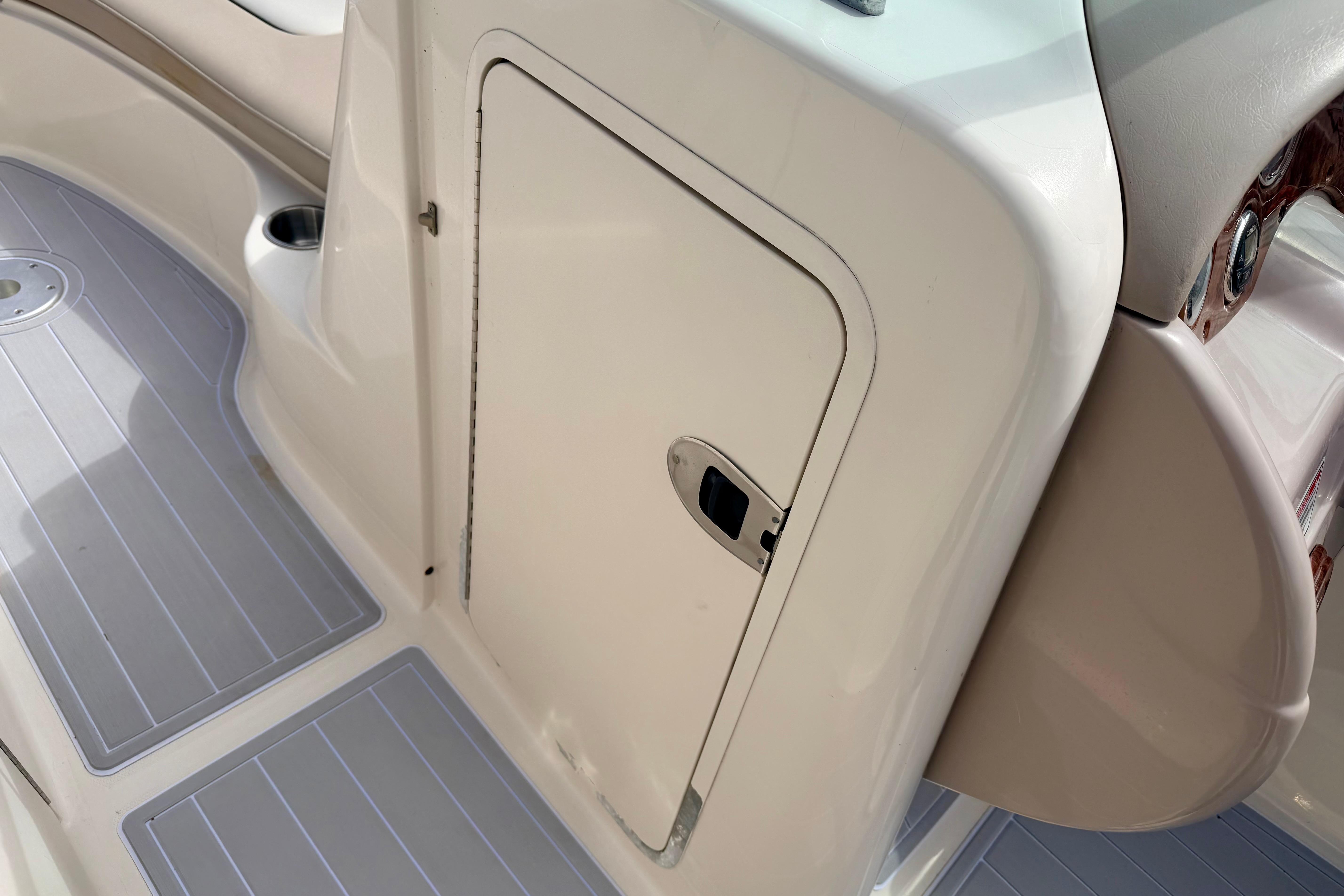 2003 Sea Ray 200 Sundeck interior with storage compartment and non-slip flooring.