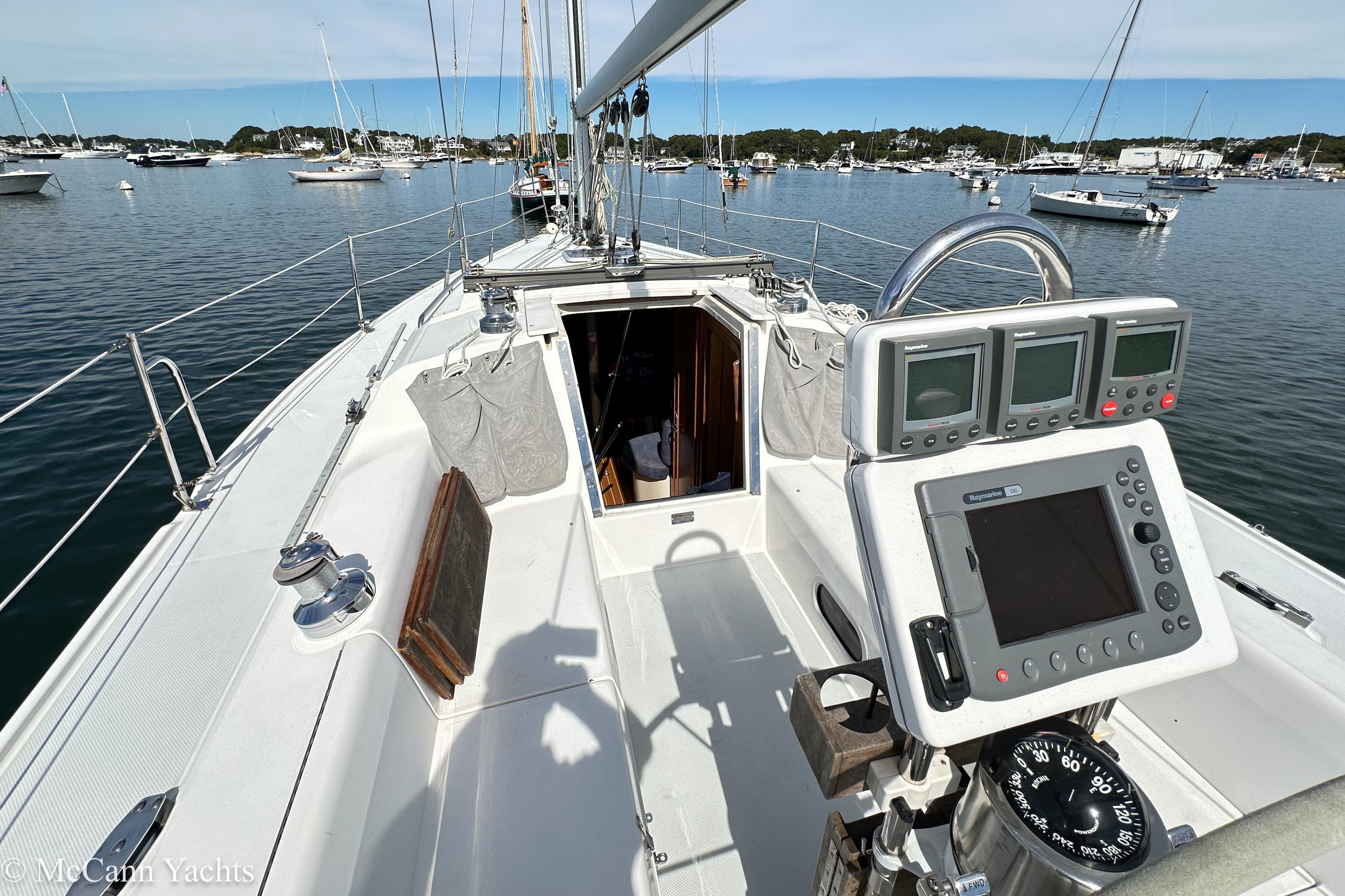 2003 Catalina 320 sailboat cockpit with navigation instruments, moored in a scenic harbor.