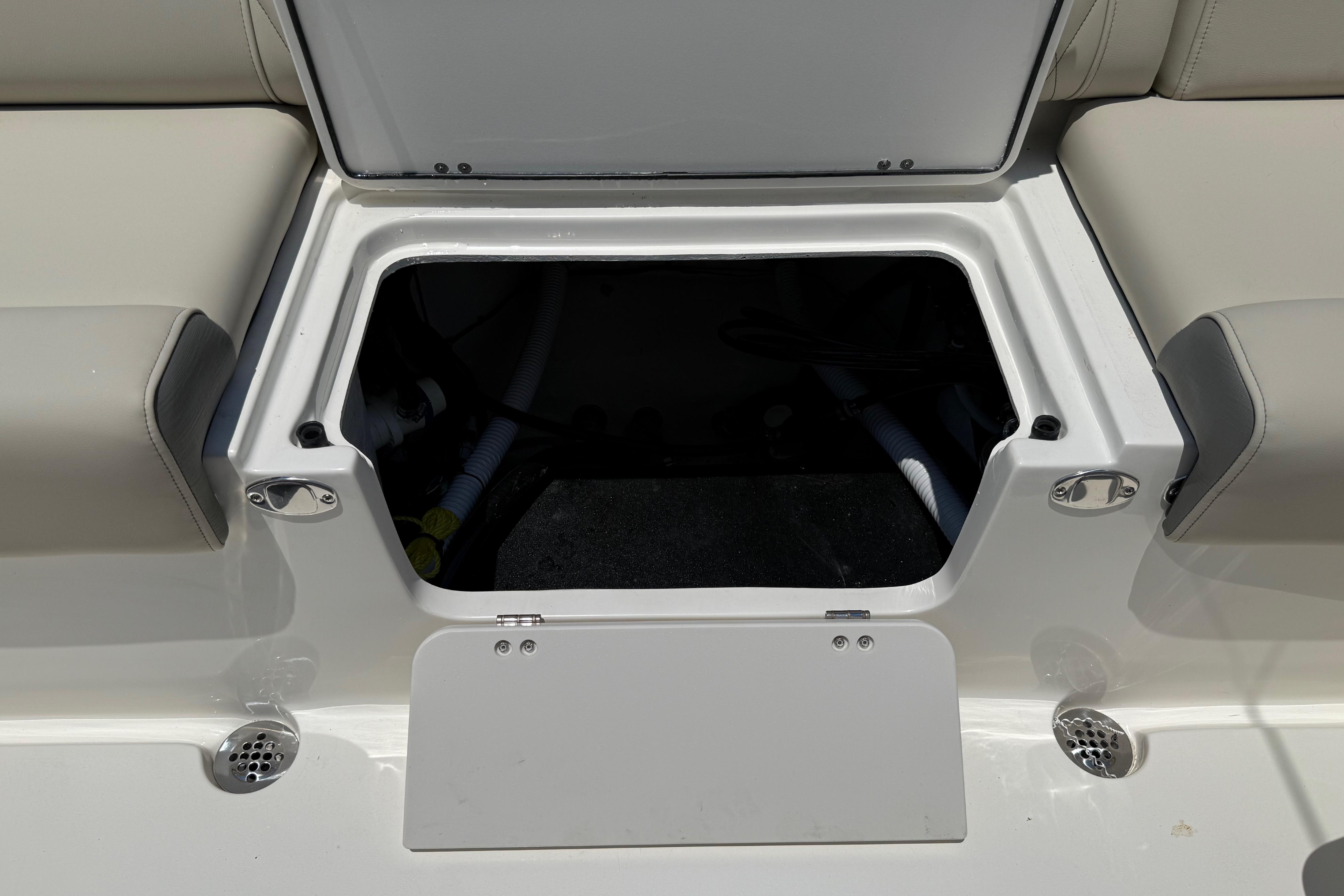 Open storage compartment on 2027 Key West 249 FS boat, featuring cushioned seating.