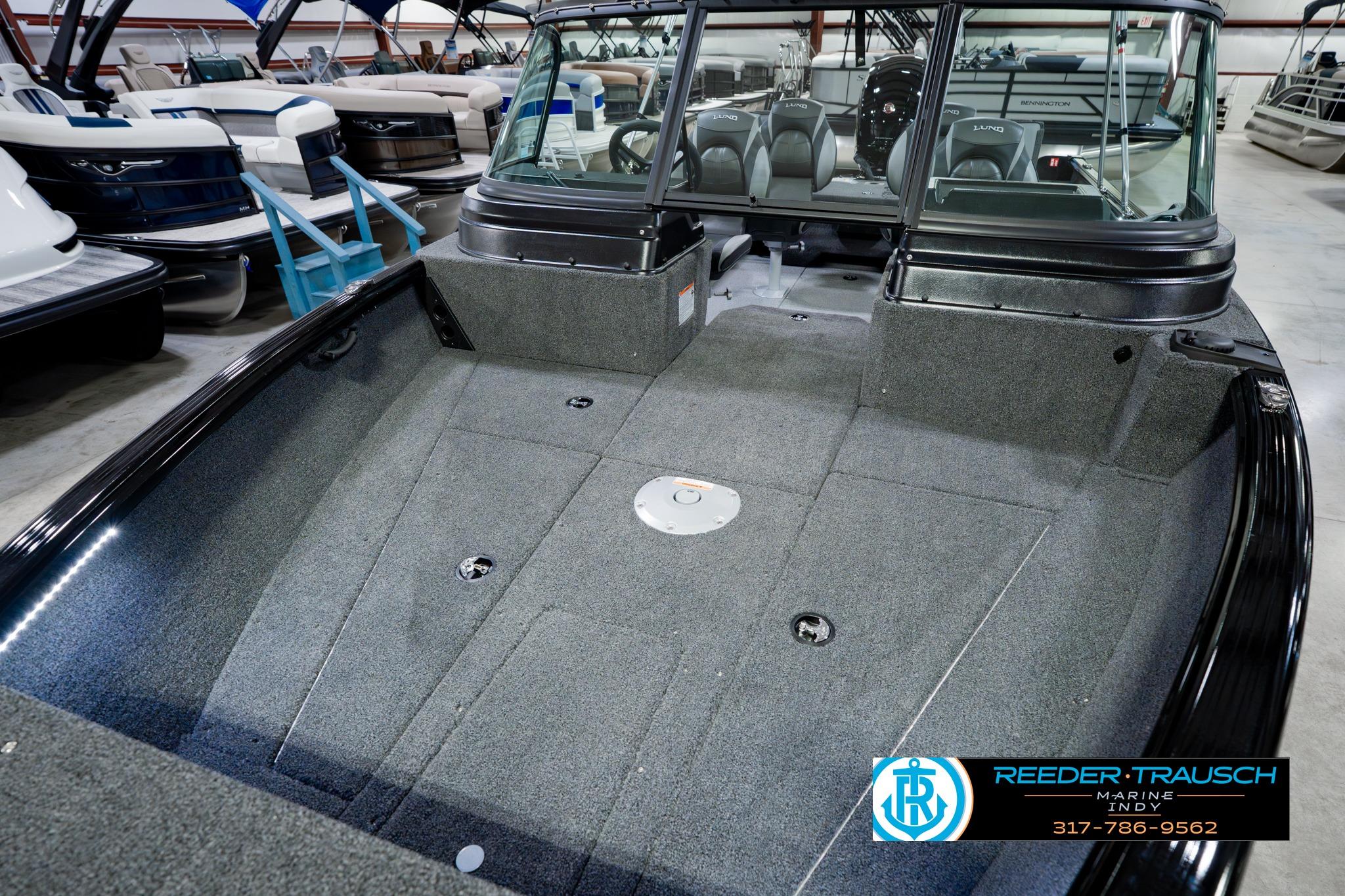 2026 Lund 1875 Impact XS boat interior, spacious deck, gray carpeting, showroom display.
