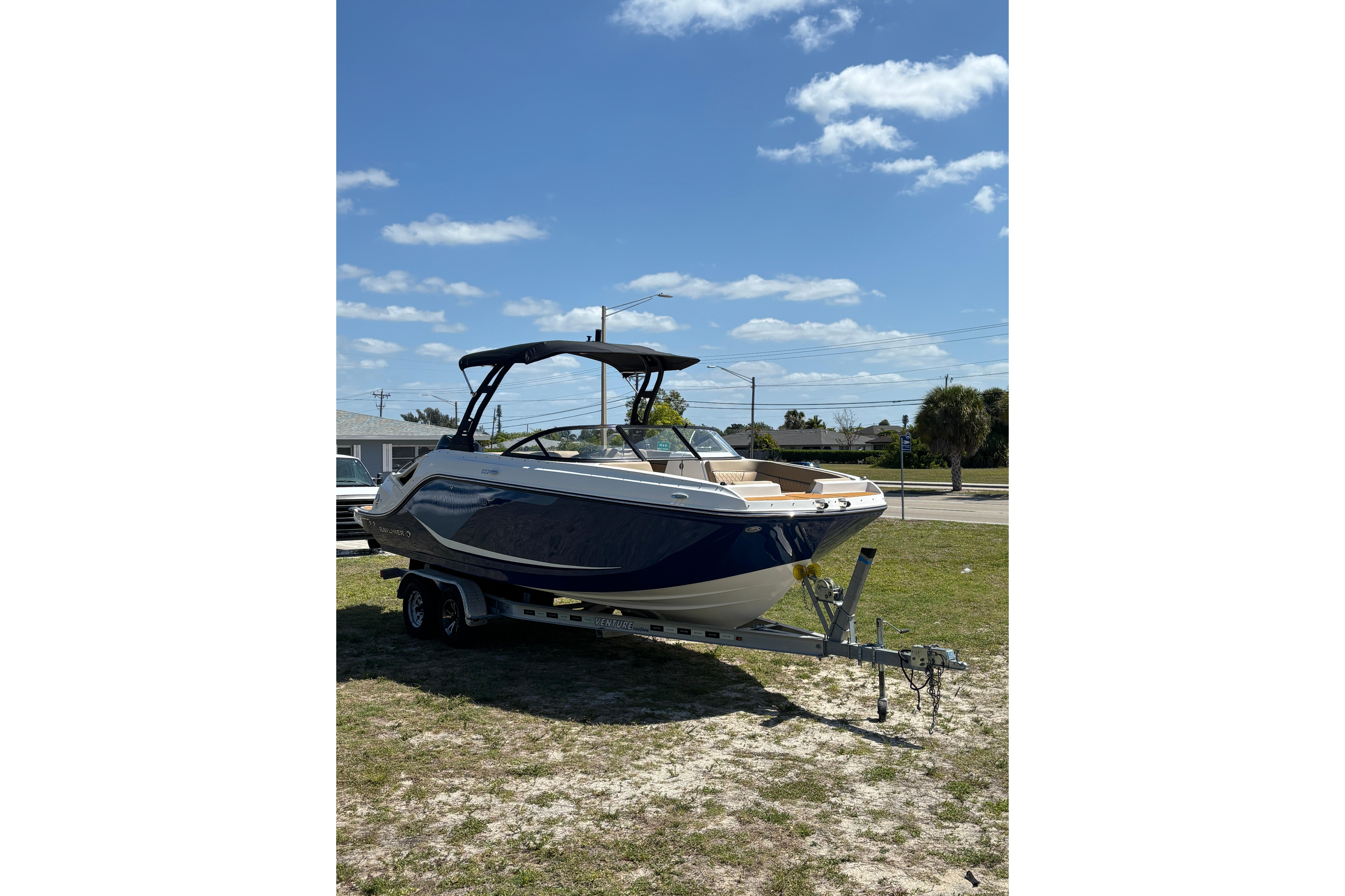 2026 Bayliner D22 boat on trailer under clear blue sky.