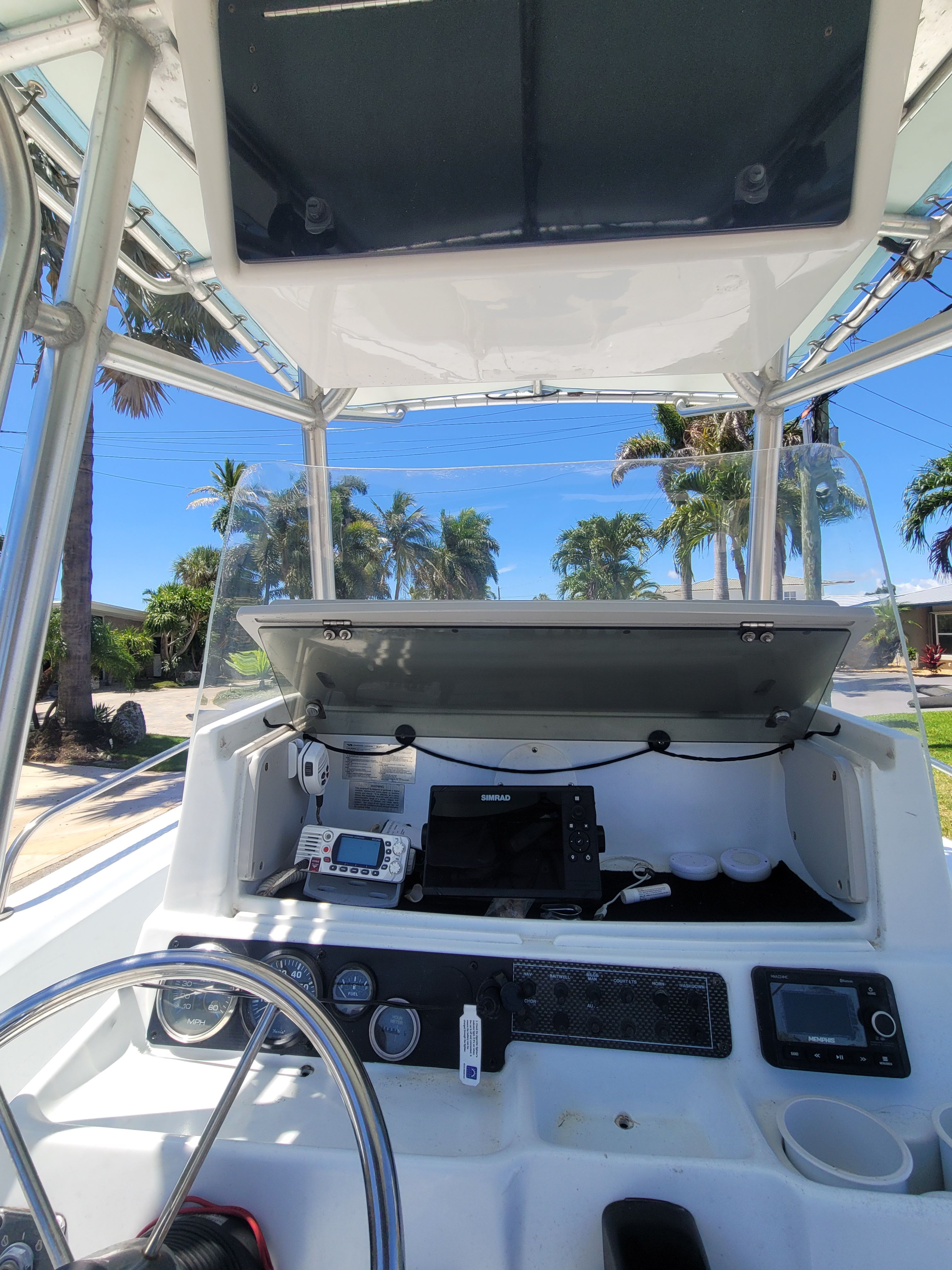 The cockpit of a 2005 Triumph VS with steering wheel and electronics under an open compartment.
