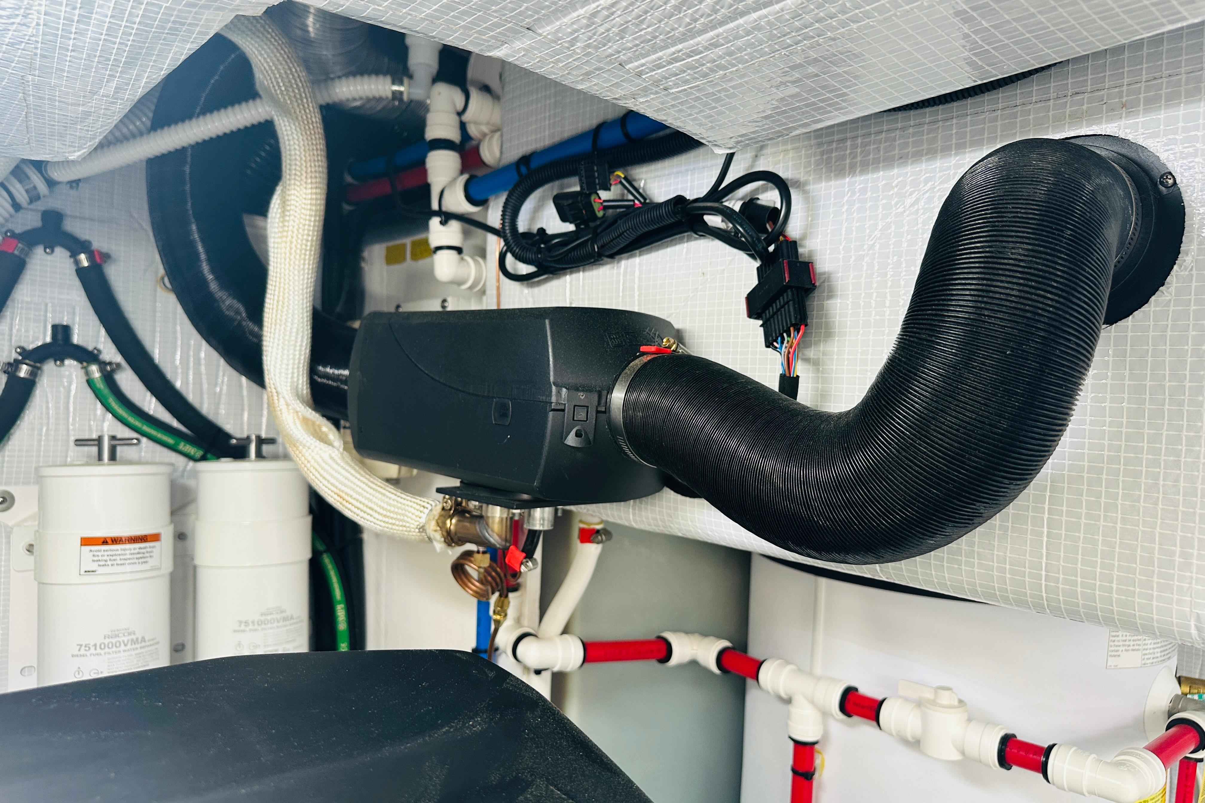 Engine room of 2025 Sabre 48 Salon Express with complex piping and wiring.