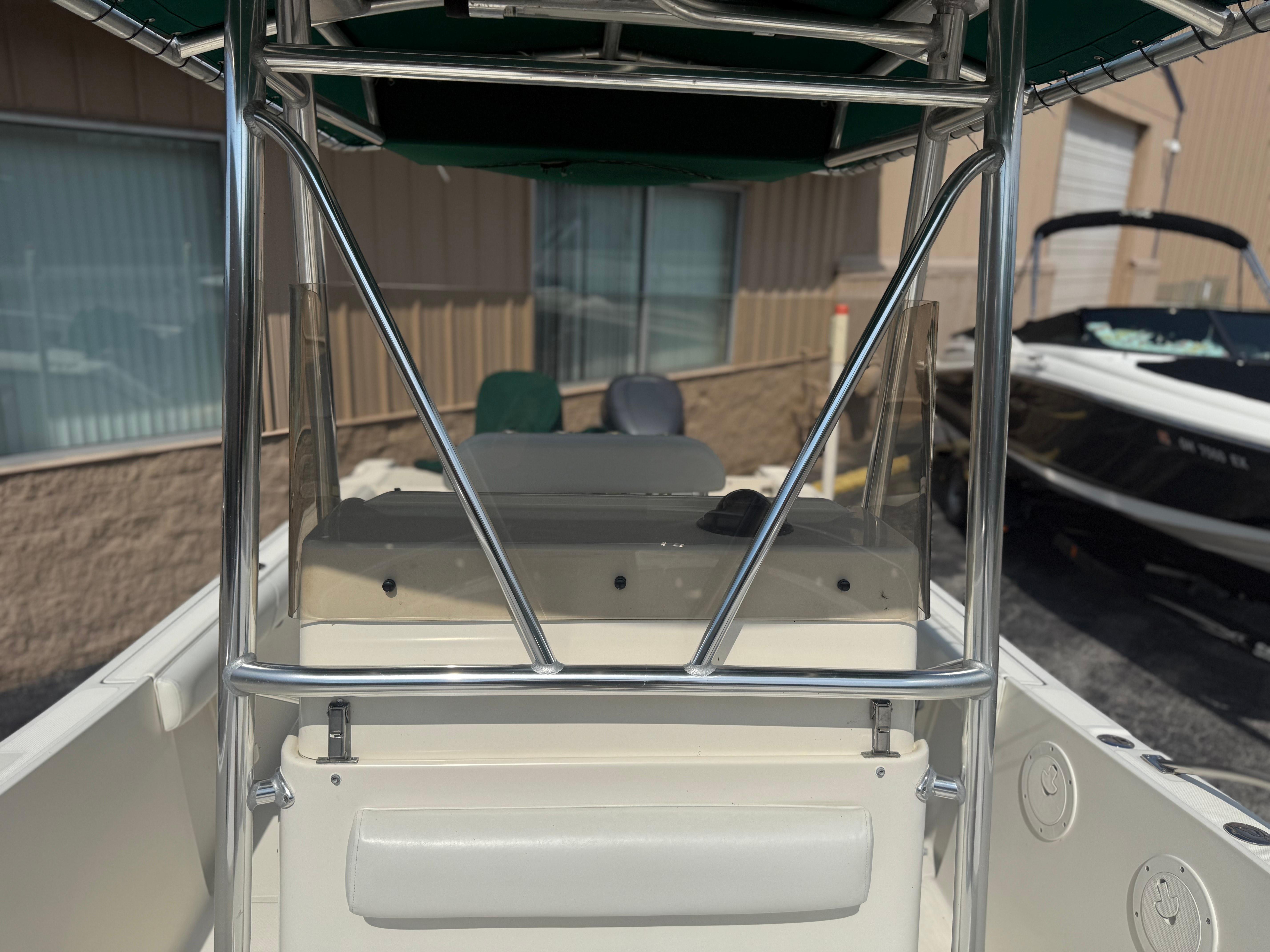 2002 Pursuit 2470 CC boat interior with T-top and console, parked outdoors.