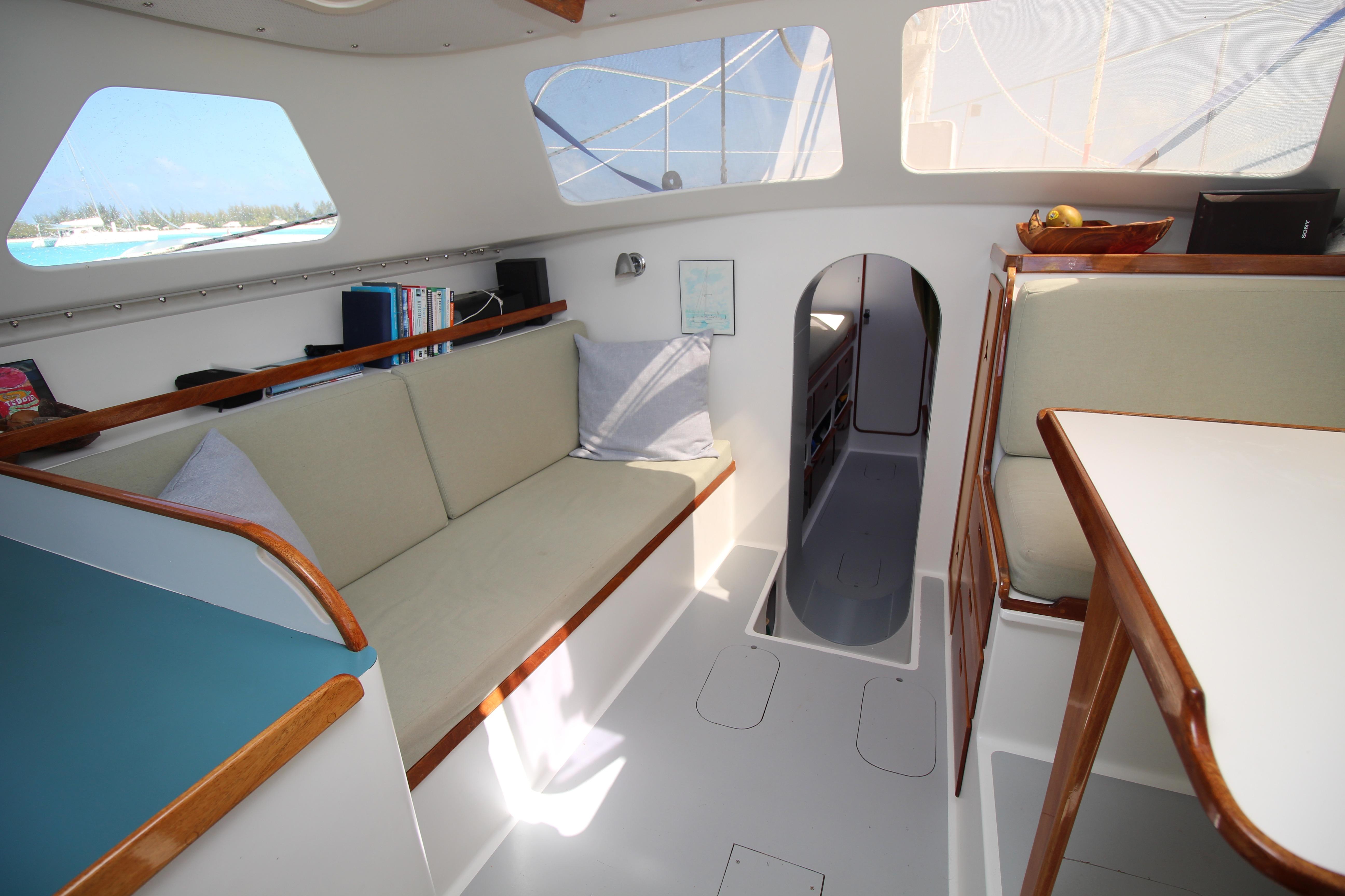 Interior of 2002 Chris White Banks Cove Hammerhead 54 sailboat, featuring cozy seating and natural light.