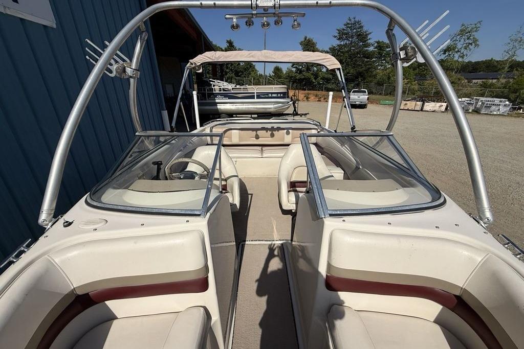 1999 Glastron GT 225 boat with dual windshields and seating, parked outdoors.