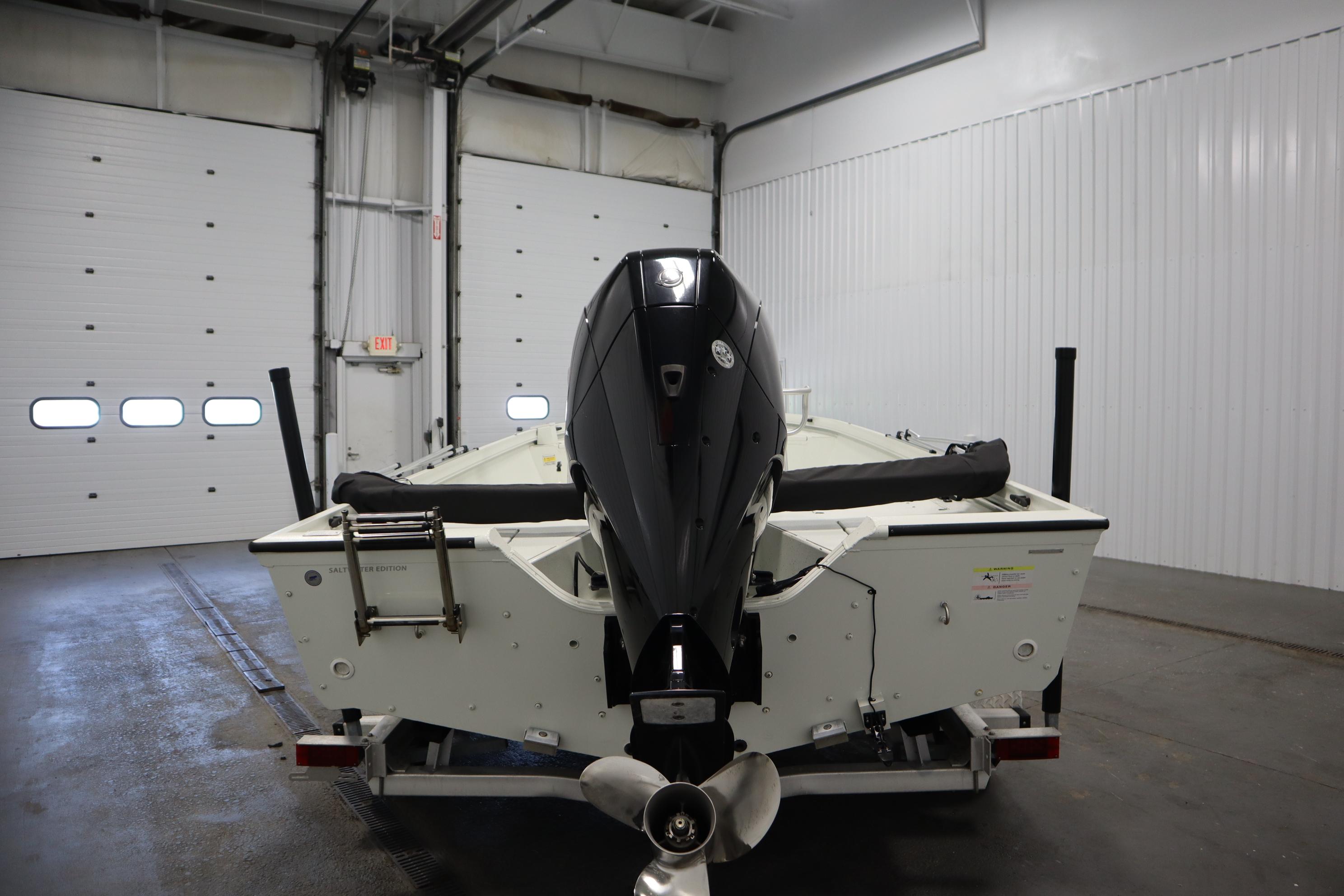 2022 Crestliner 2200 CC boat in a garage, rear view with motor.