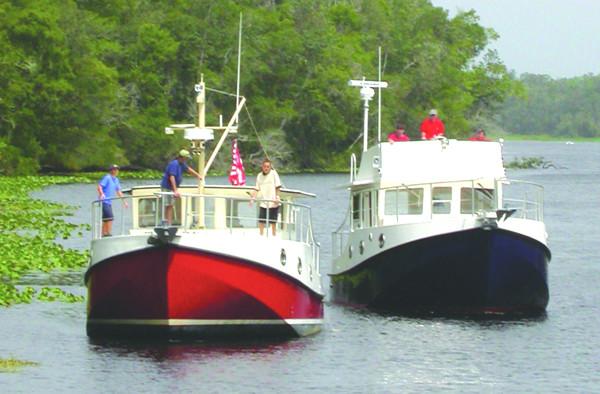 Two Great Harbour N40 boats on a river, surrounded by lush greenery, 2025 model.