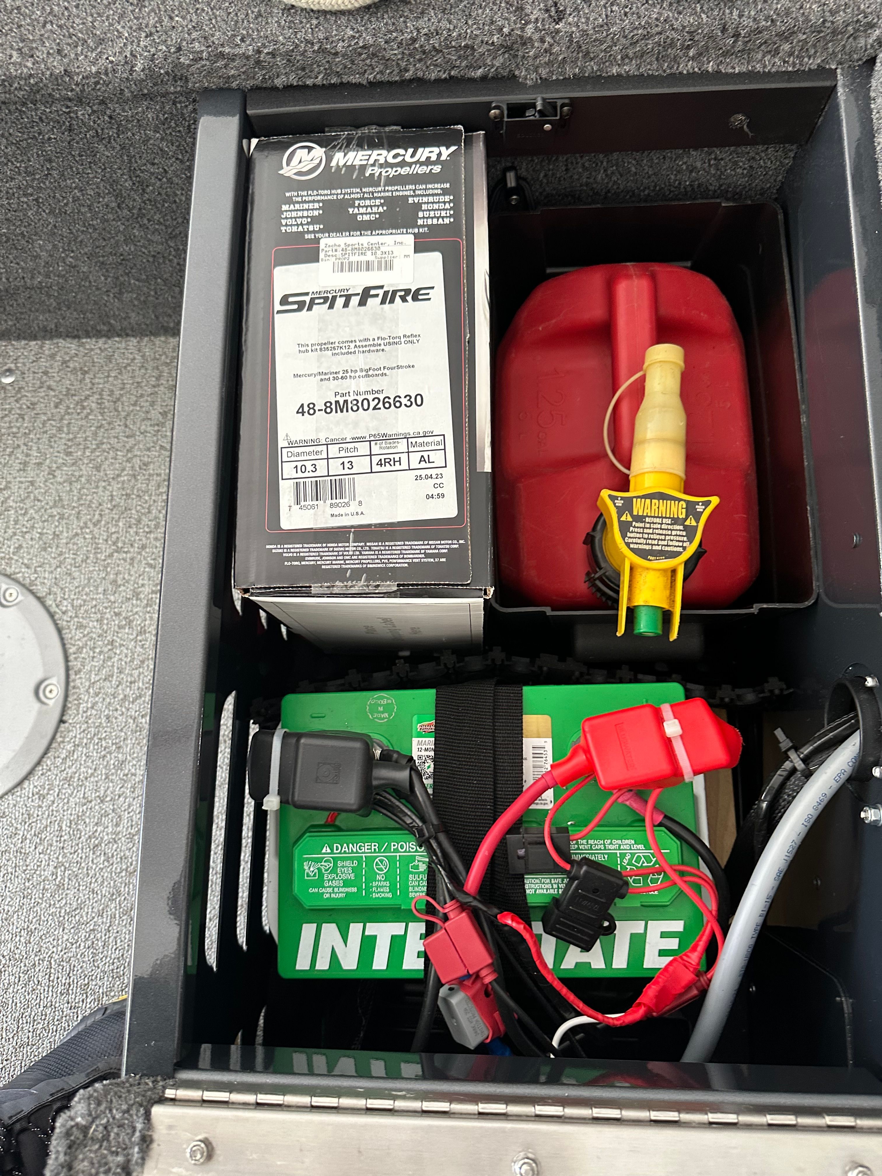 A battery compartment with a Mercury Spitfire box, a red fuel can, and a green battery.