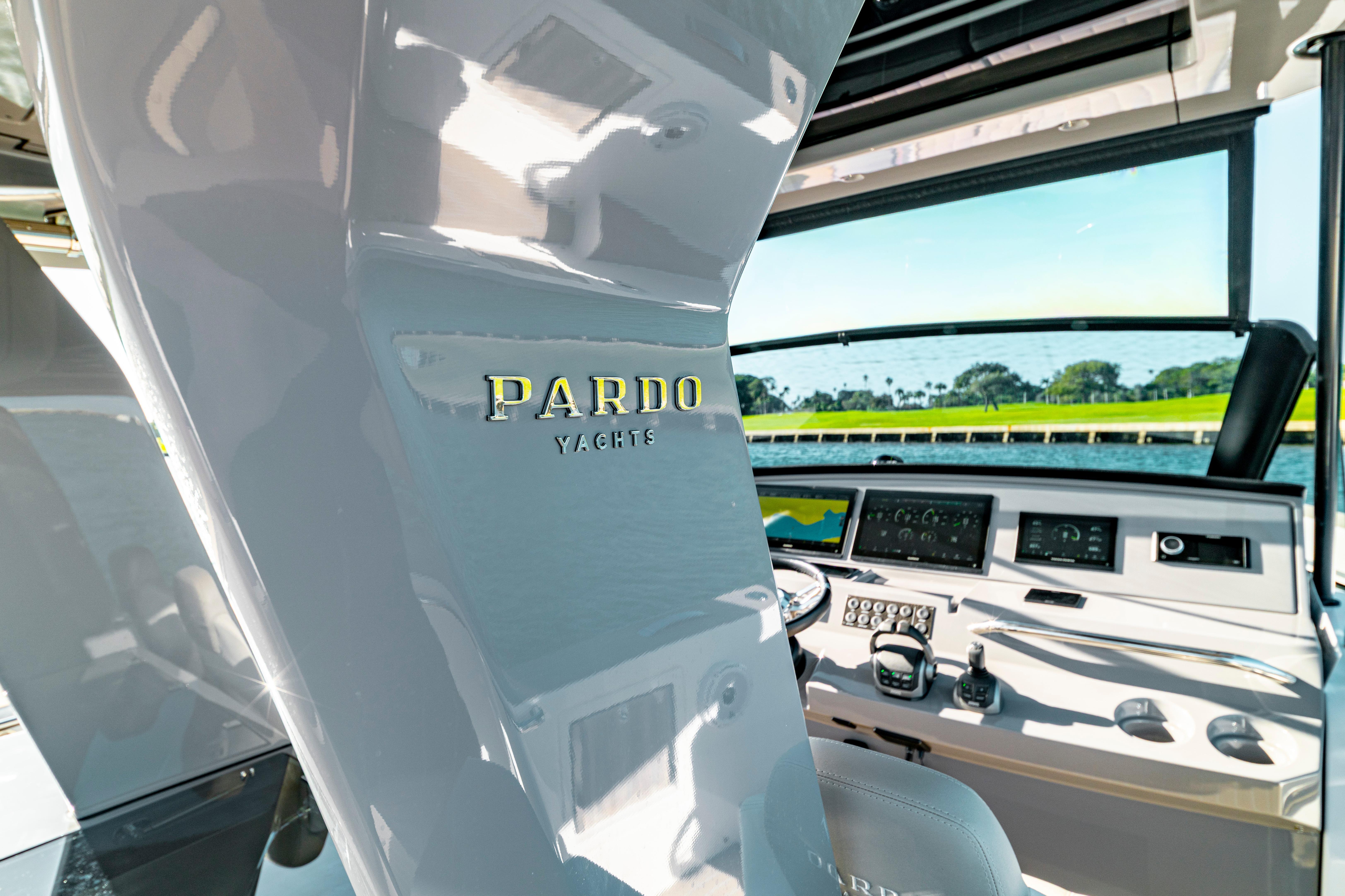 Interior view of 2024 Pardo Yachts P43 helm with modern controls and scenic waterway.