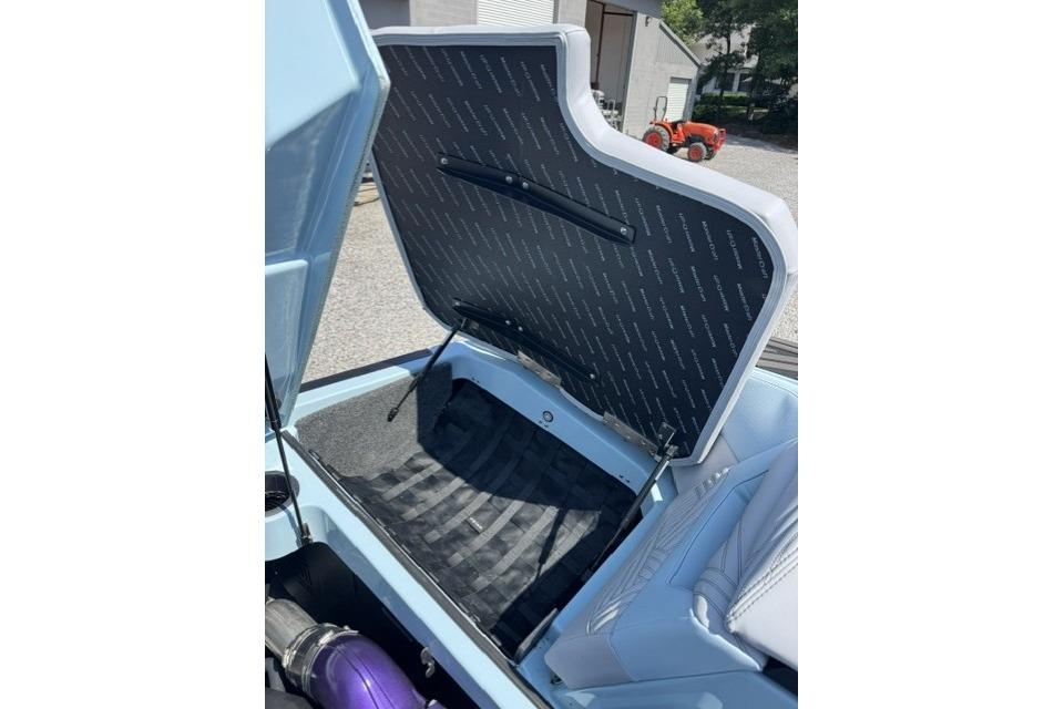 Open storage compartment in 2026 MasterCraft XStar 25 boat, showcasing interior design.