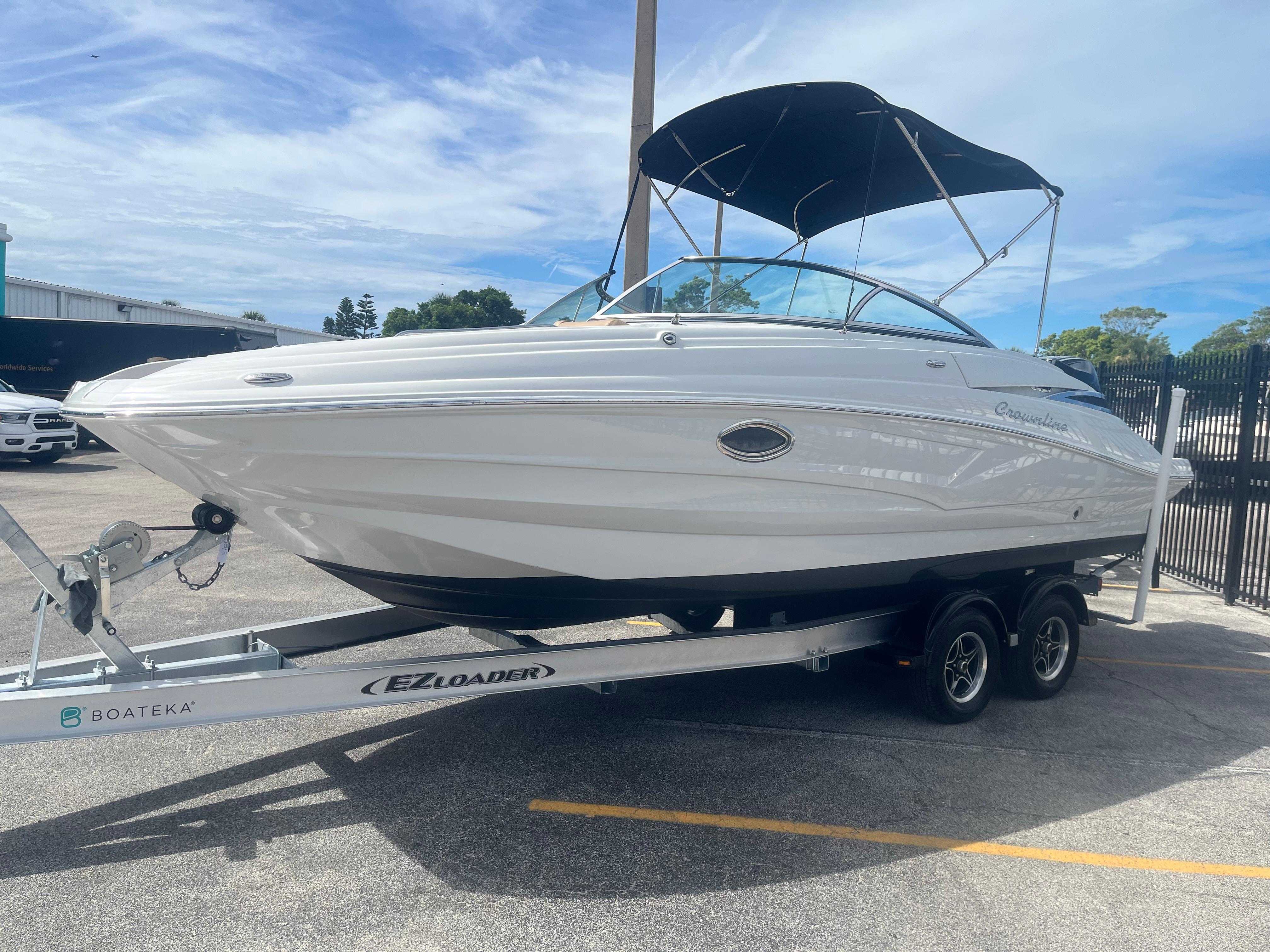 2022 Crownline Eclipse E235 XS boat on trailer, parked outdoors under blue sky.