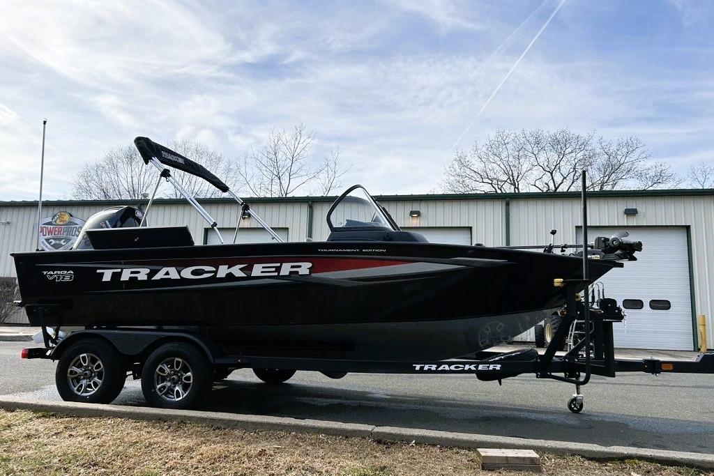 2026 Tracker Targa V-18 Combo boat on trailer, parked outside a warehouse.