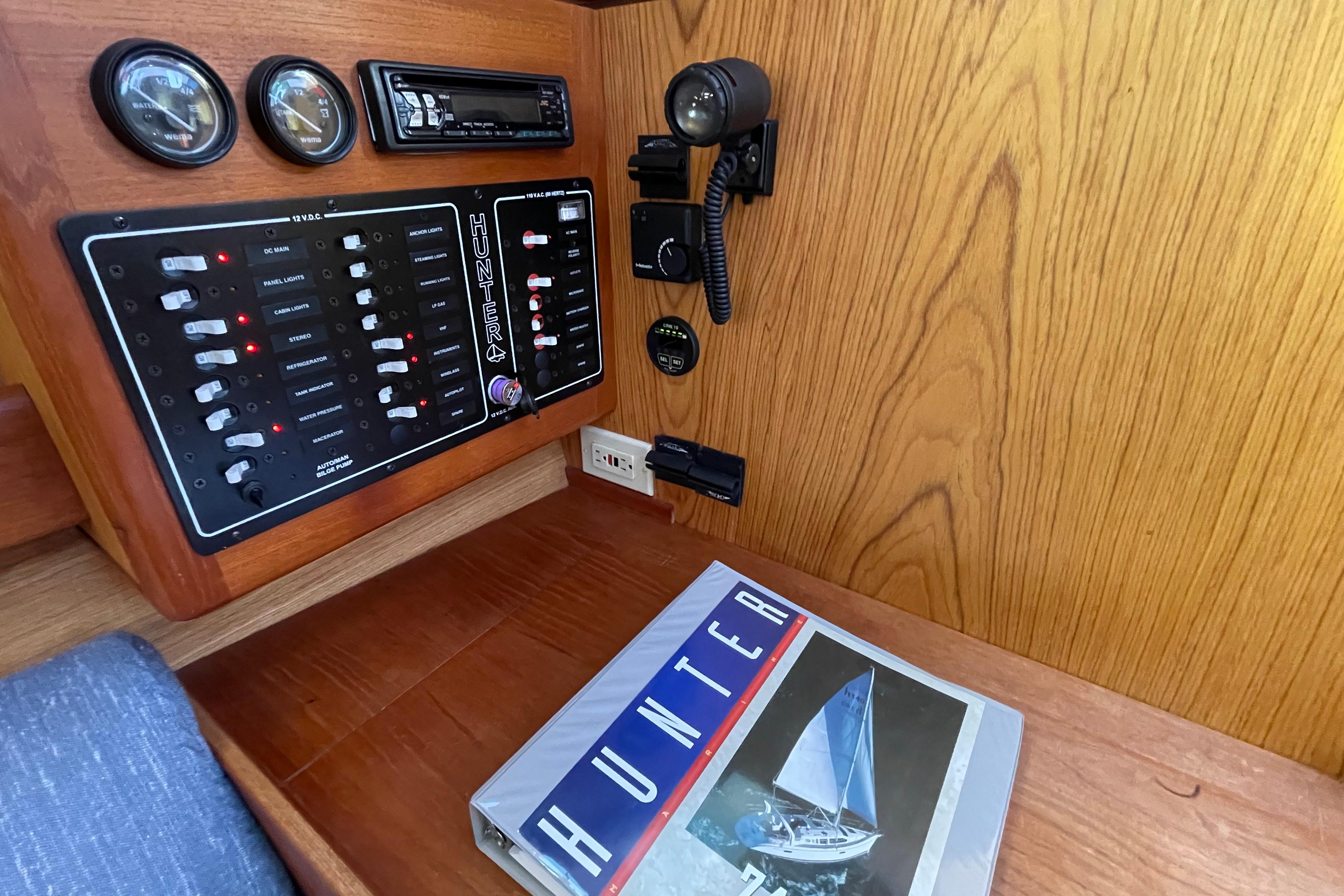 Control panel and manual inside a 2000 Hunter 340 sailboat cabin.