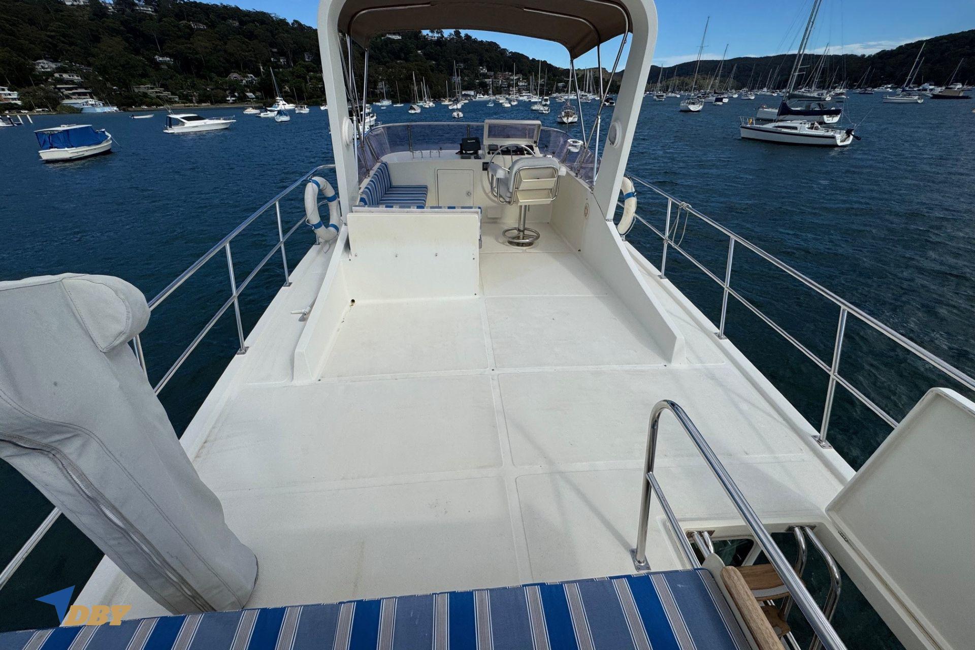 Flybridge of 2006 Clipper 34 yacht with seating, overlooking a scenic harbor.