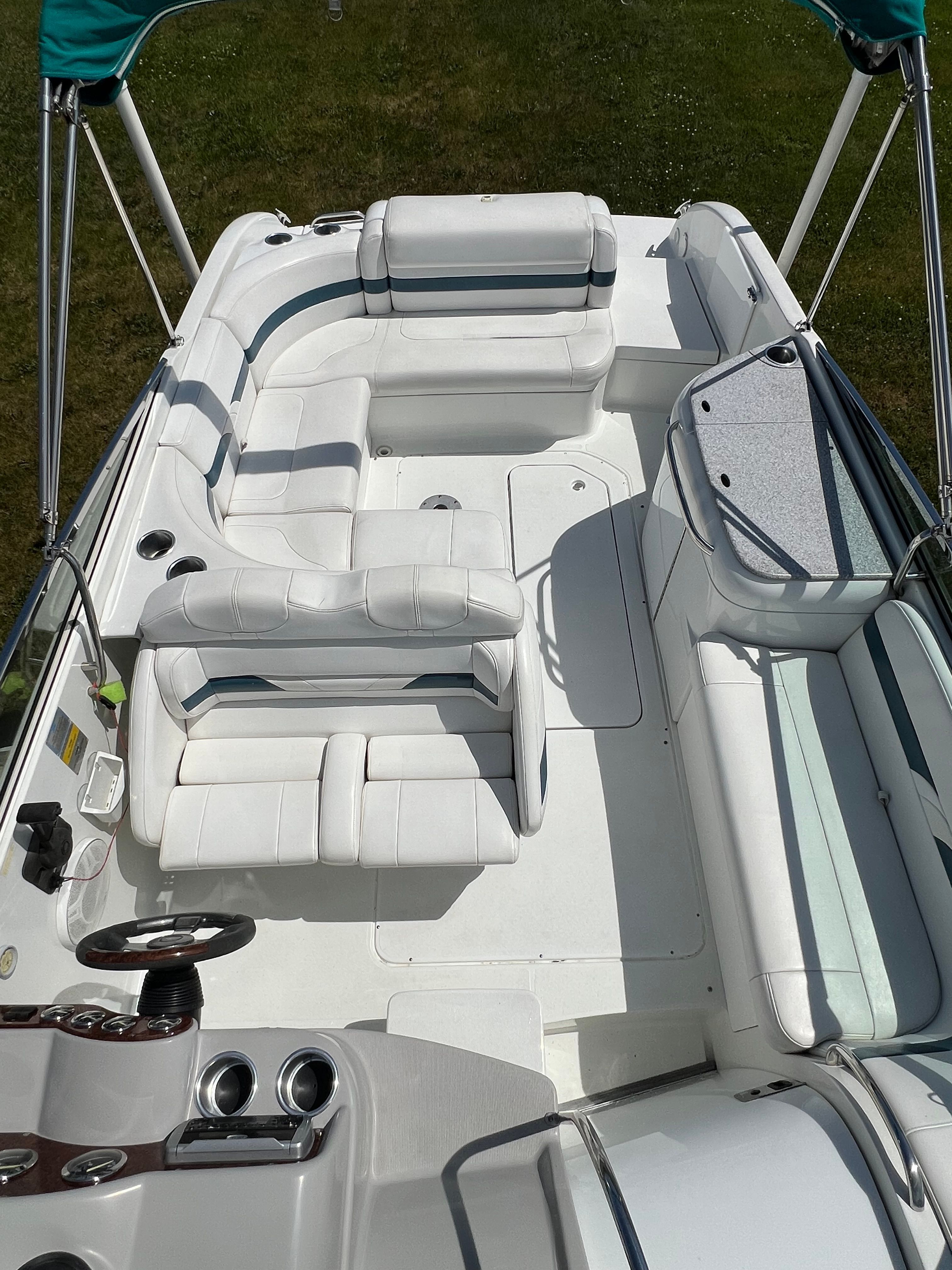 The image shows the cockpit of a 2005 Formula 260 Sun Sport with white cushioned seating and a helm.