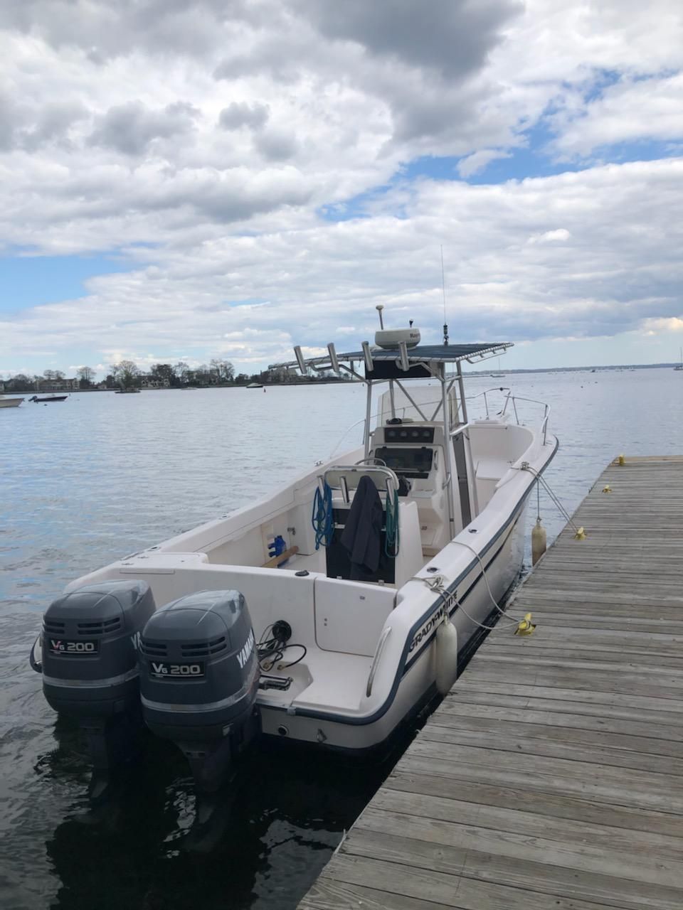 A 1997 Grady-White Chase 263 boat docked. It features twin outboard engines.