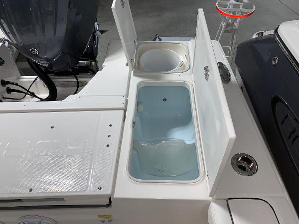 2024 Robalo 246 Cayman boat with open storage compartments and engine.