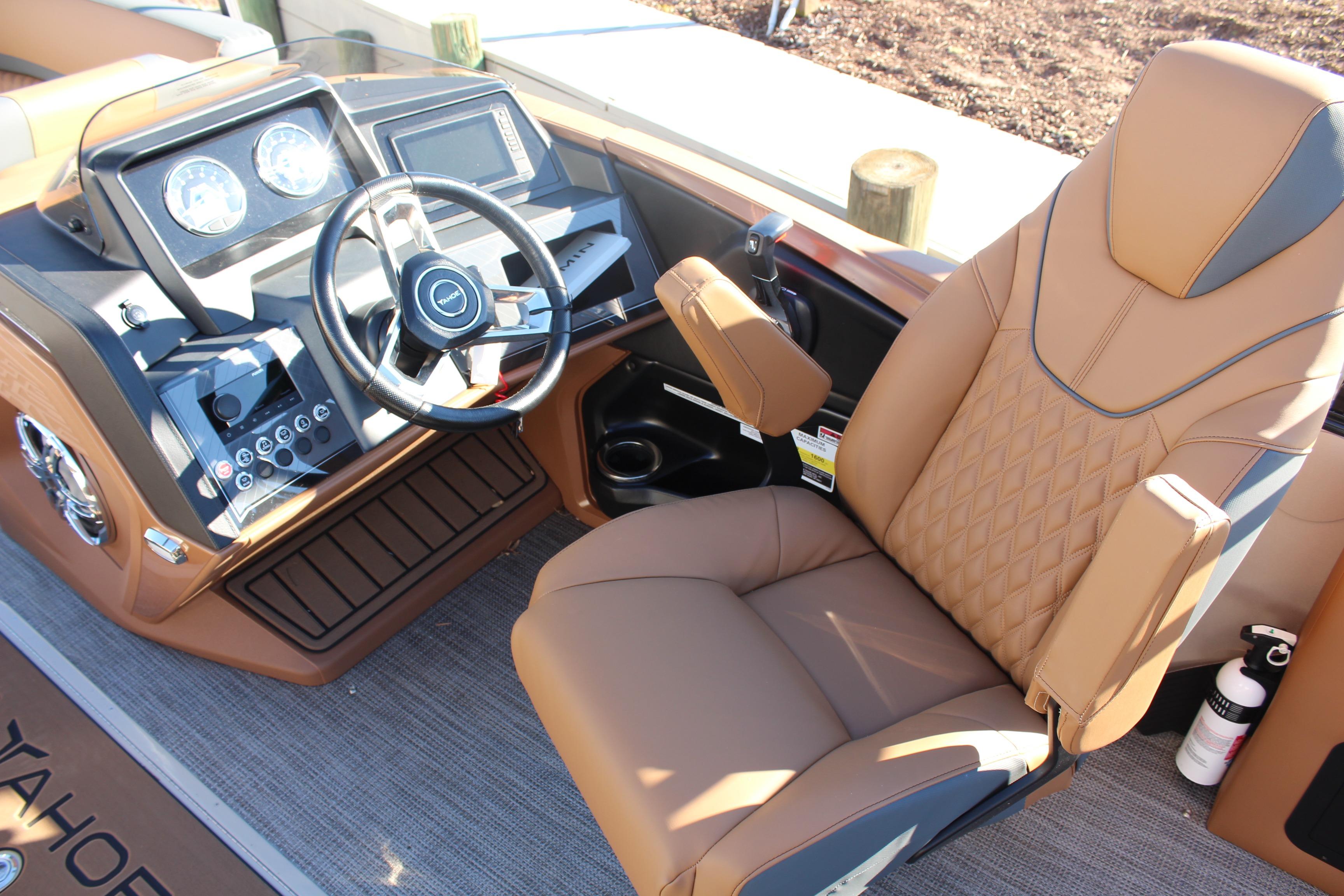 Luxurious 2026 Tahoe Pontoon Cascade Versatile Rear Bench captain's chair and dashboard.