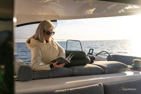 Woman reading on Nautitech 48 Open yacht, 2025 model, at sea.