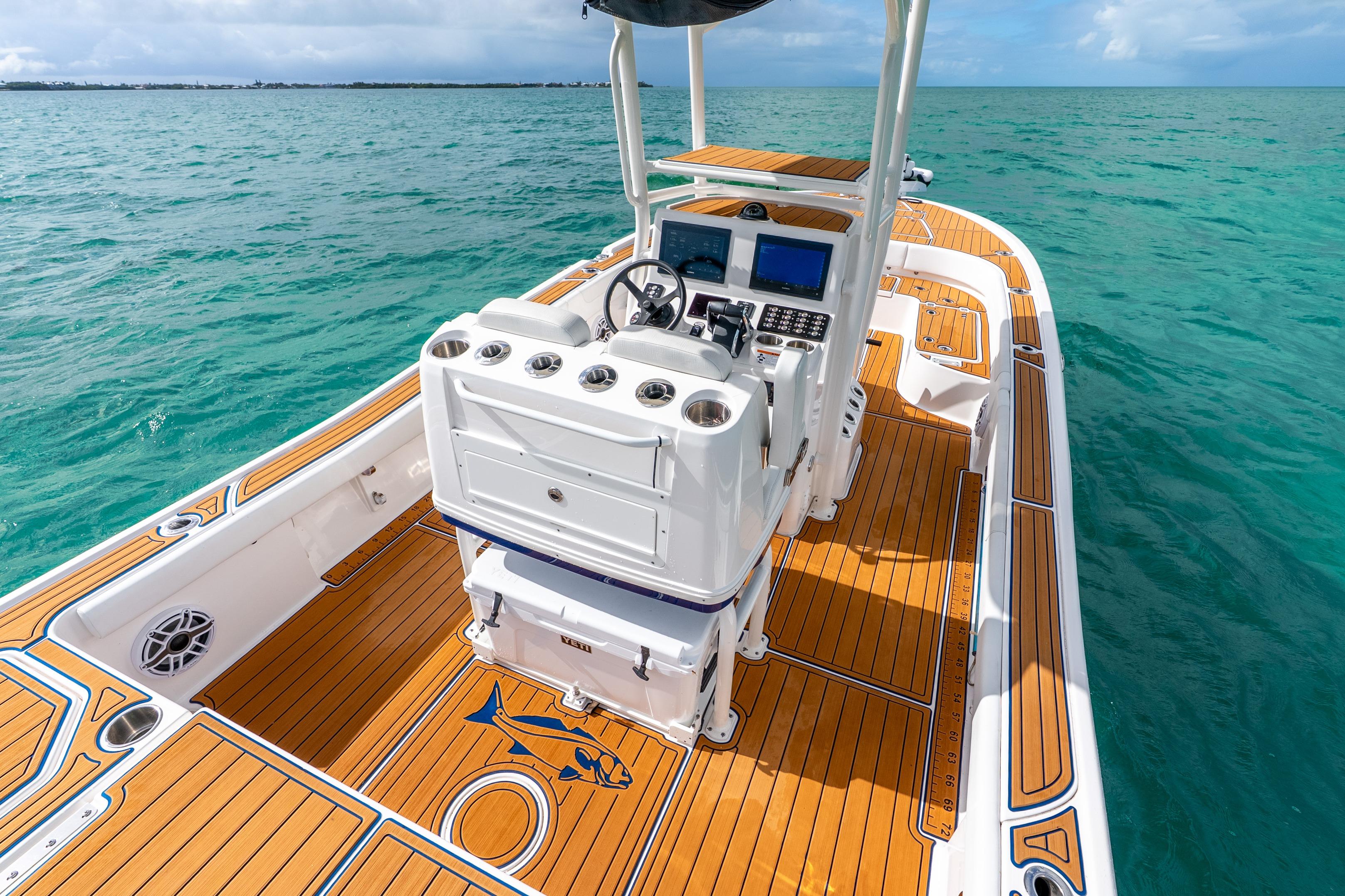 2024 Caymas 281 HB boat with teak deck, navigating clear blue waters.