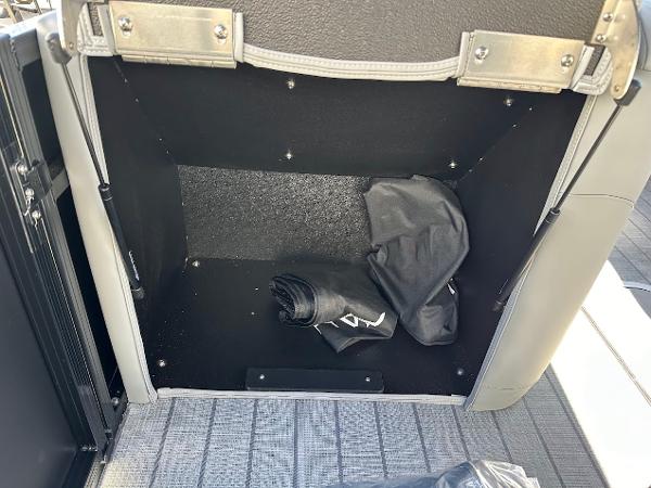 Storage compartment in 2025 Tahoe Pontoon 2585 LTZ Entertainer with folded cover inside.