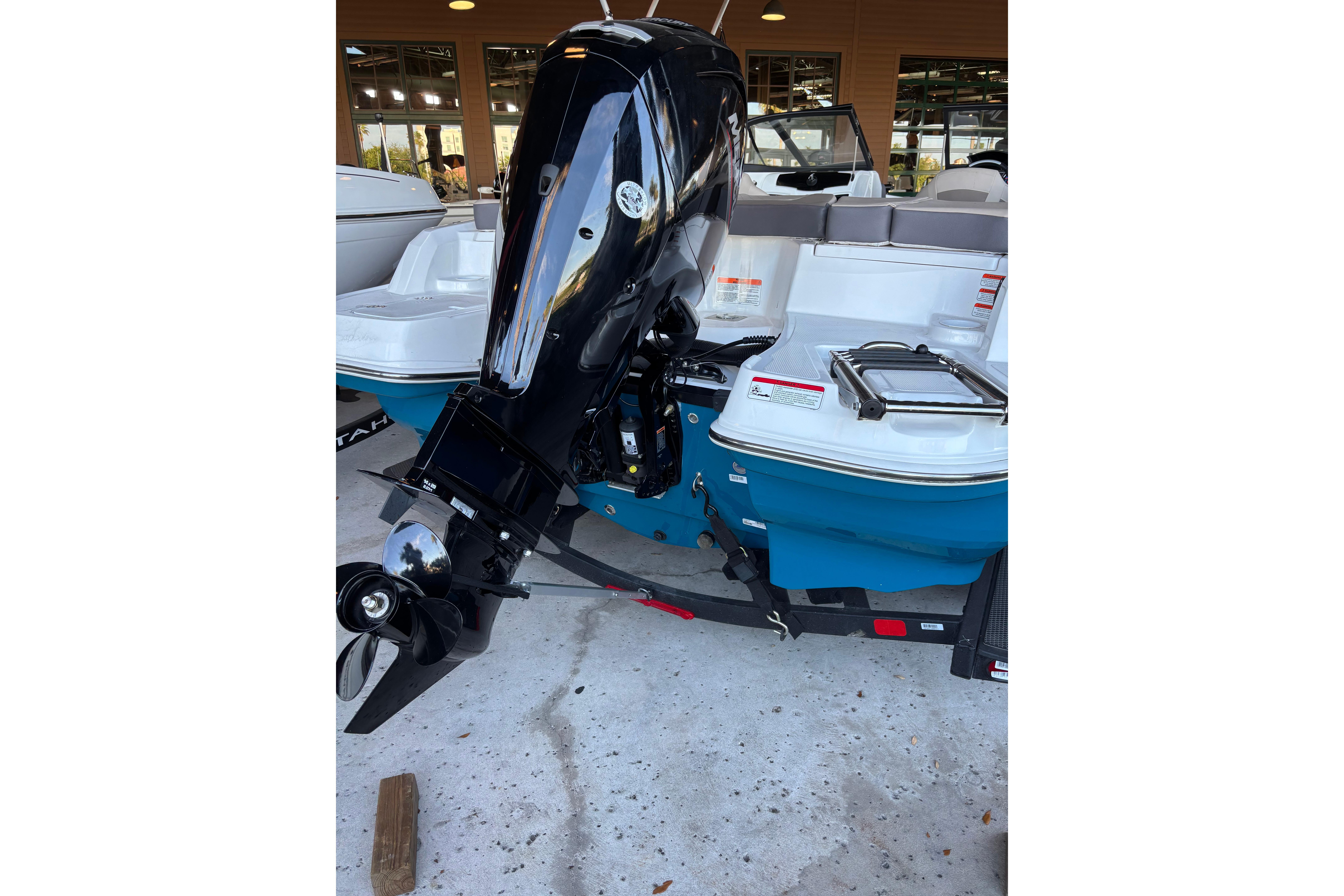 2025 Tahoe 200 S boat with powerful outboard motor in showroom.