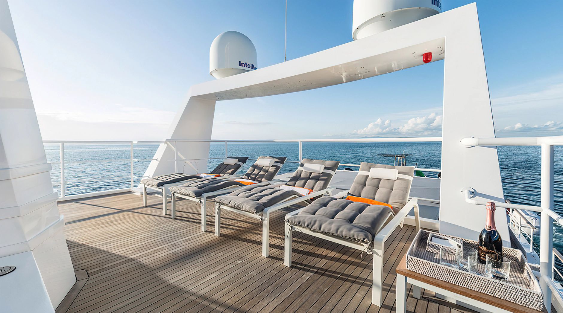 Luxurious sun loungers on a yacht deck overlooking the sea.